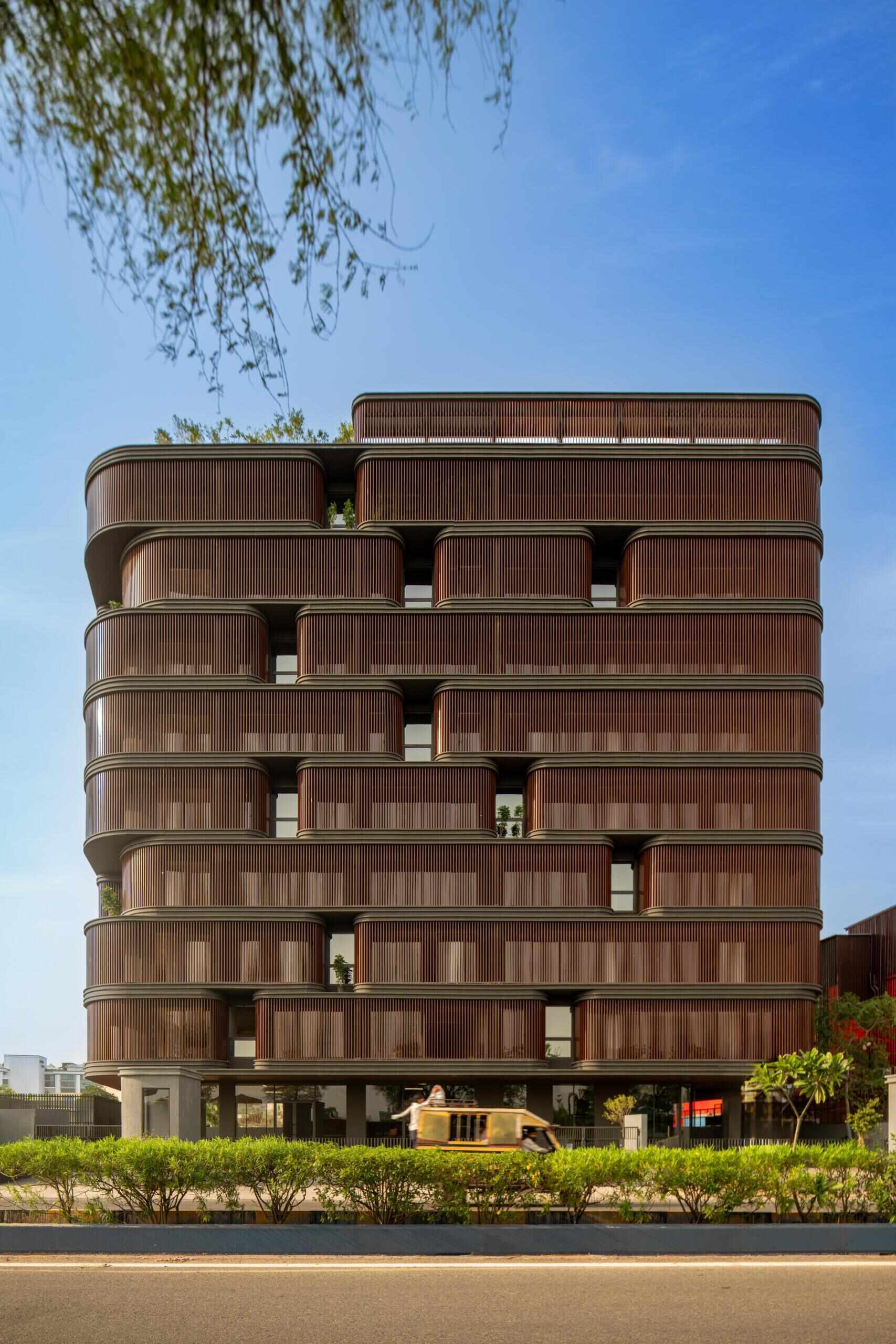 This office building combines capsule-shaped architecture, flexible workspaces, rooftop gardens, planter terraces, natural ventilation, and passive cooling strategies to create a greener, more comfortable workplace in one of India's hottest climates.
