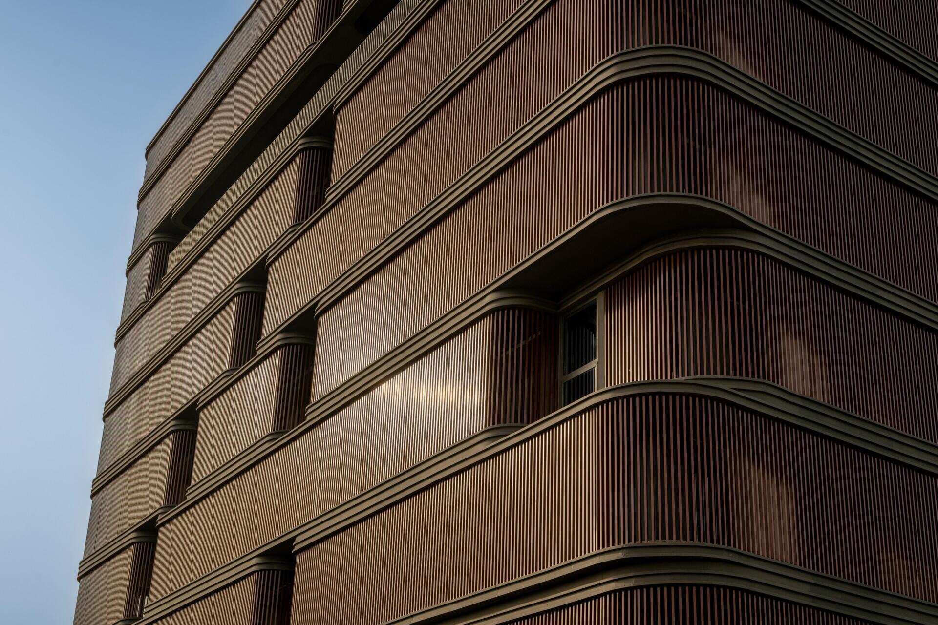 This office building combines capsule-shaped architecture, flexible workspaces, rooftop gardens, planter terraces, natural ventilation, and passive cooling strategies to create a greener, more comfortable workplace in one of India's hottest climates.