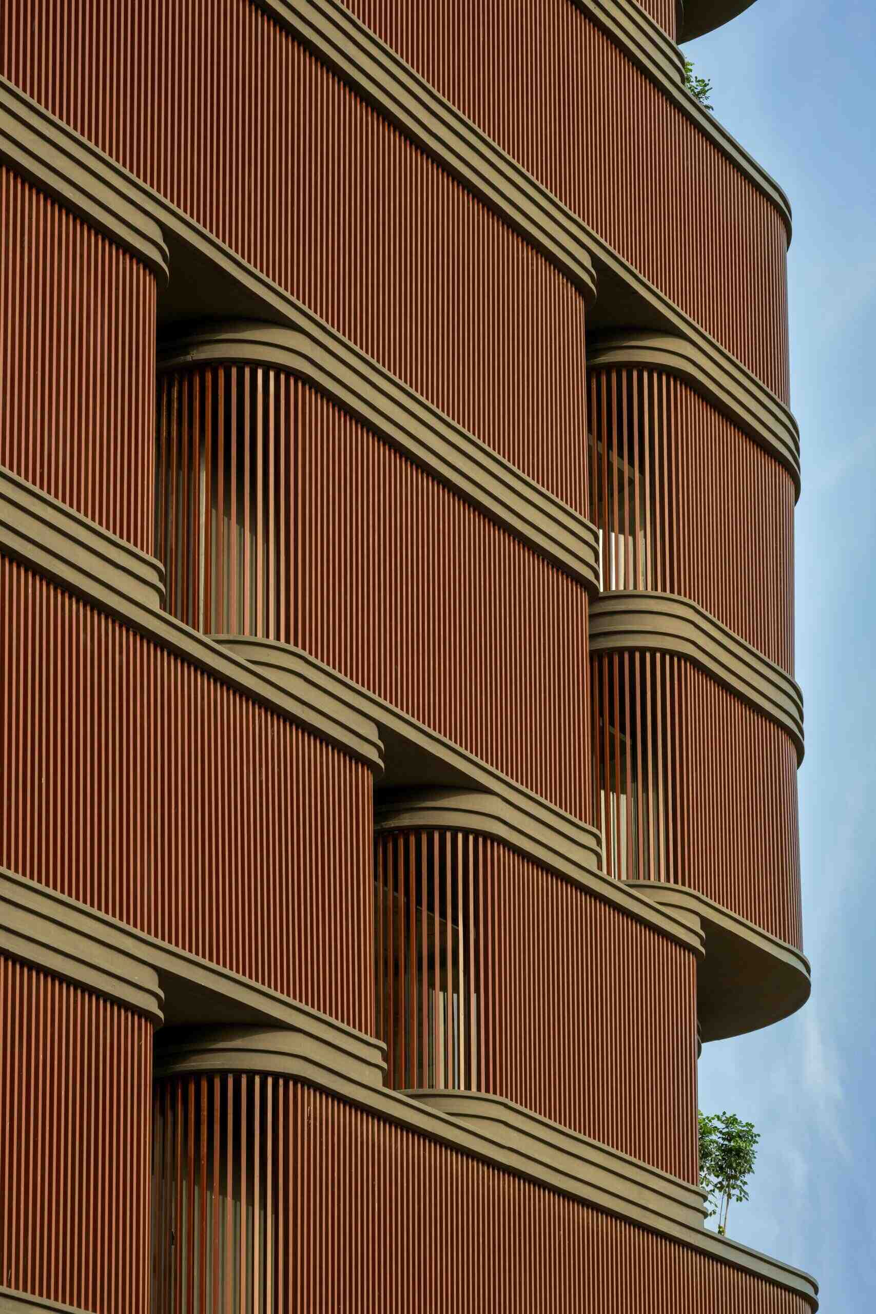 This office building combines capsule-shaped architecture, flexible workspaces, rooftop gardens, planter terraces, natural ventilation, and passive cooling strategies to create a greener, more comfortable workplace in one of India's hottest climates.