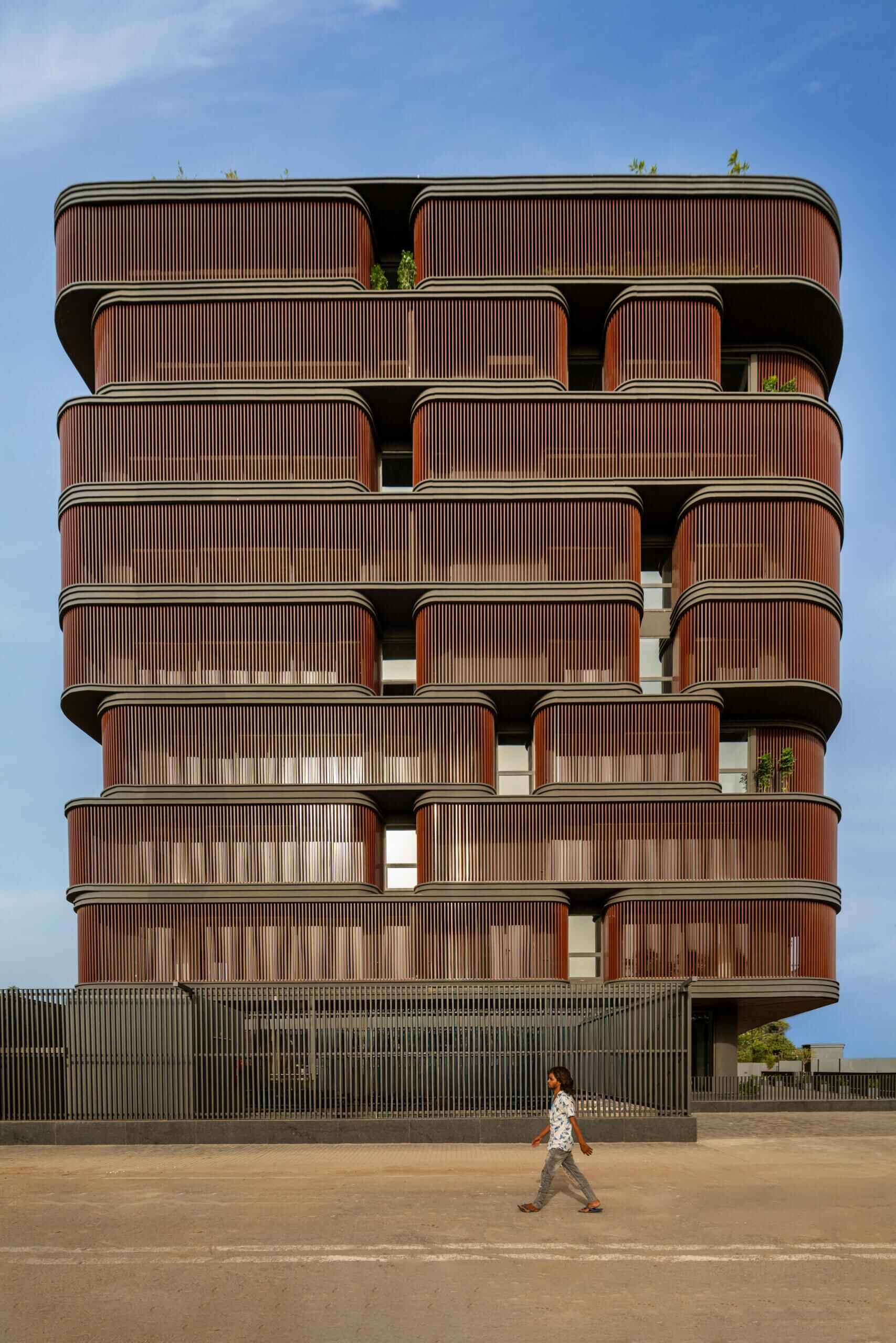 This office building combines capsule-shaped architecture, flexible workspaces, rooftop gardens, planter terraces, natural ventilation, and passive cooling strategies to create a greener, more comfortable workplace in one of India's hottest climates.