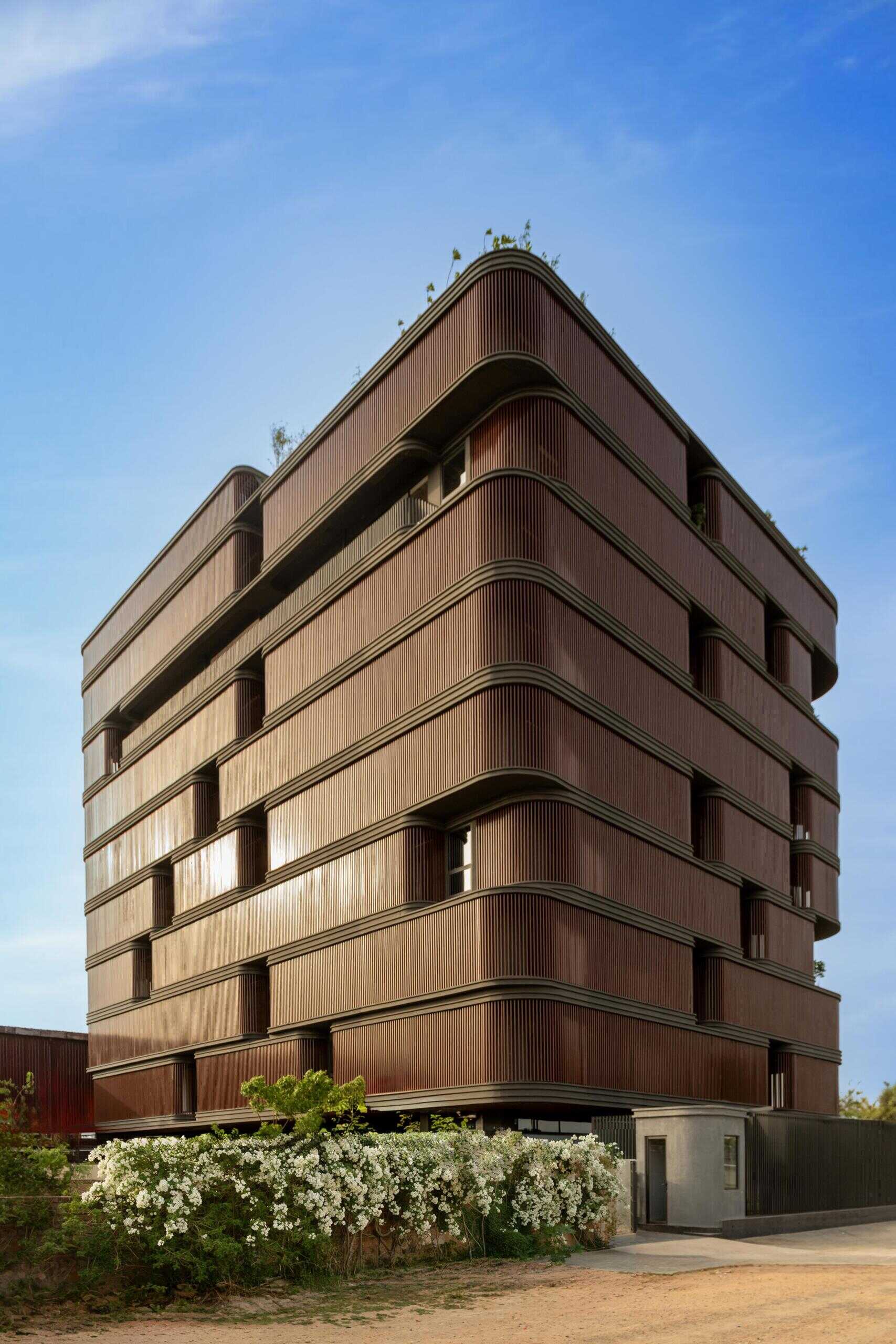 This office building combines capsule-shaped architecture, flexible workspaces, rooftop gardens, planter terraces, natural ventilation, and passive cooling strategies to create a greener, more comfortable workplace in one of India's hottest climates.