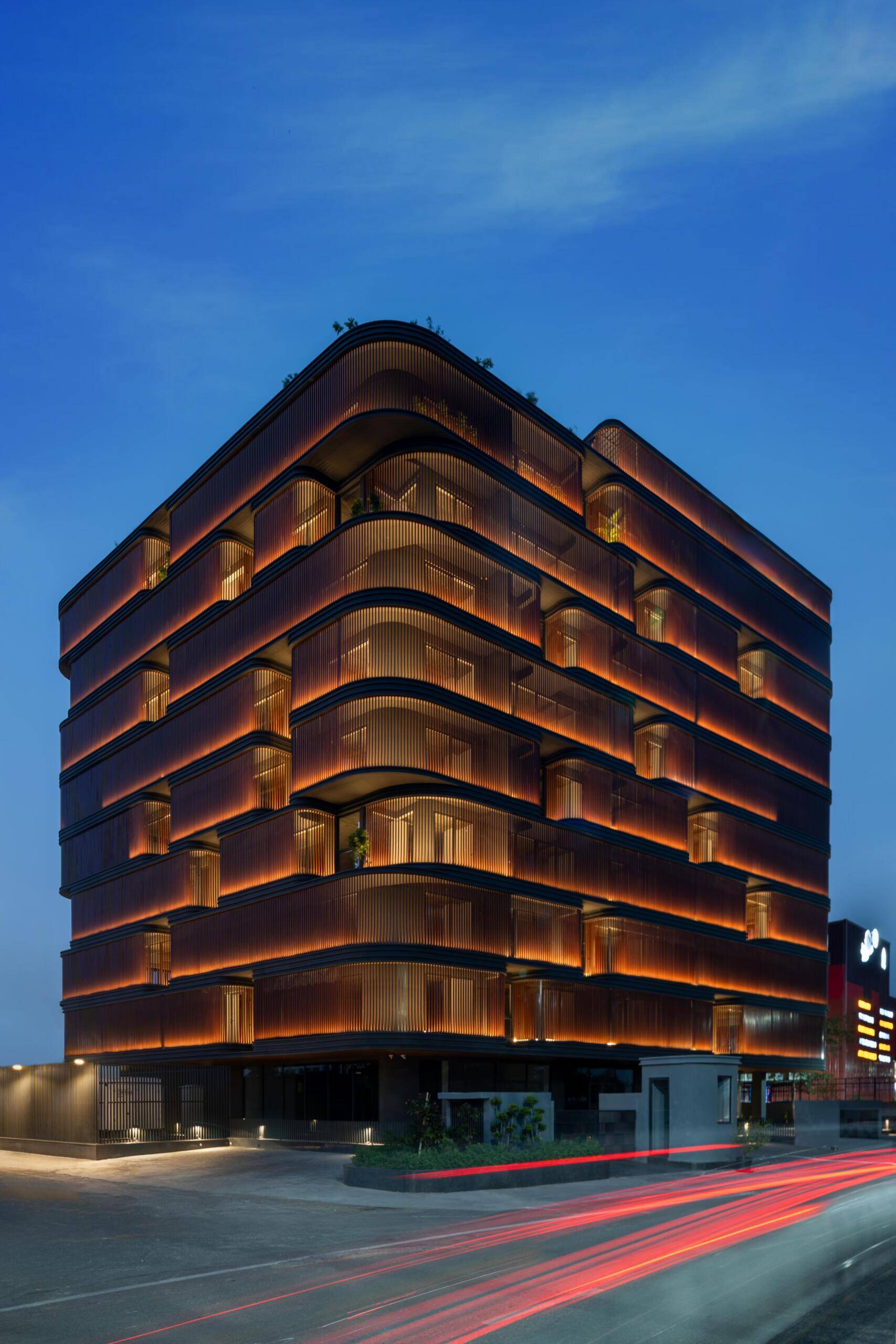 This office building combines capsule-shaped architecture, flexible workspaces, rooftop gardens, planter terraces, natural ventilation, and passive cooling strategies to create a greener, more comfortable workplace in one of India's hottest climates.