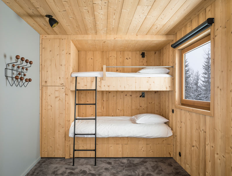 This bedroom has built-in bunk beds stretching along one wall. Storage cabinets are integrated into the design, making excellent use of the available space without making the room feel crowded.