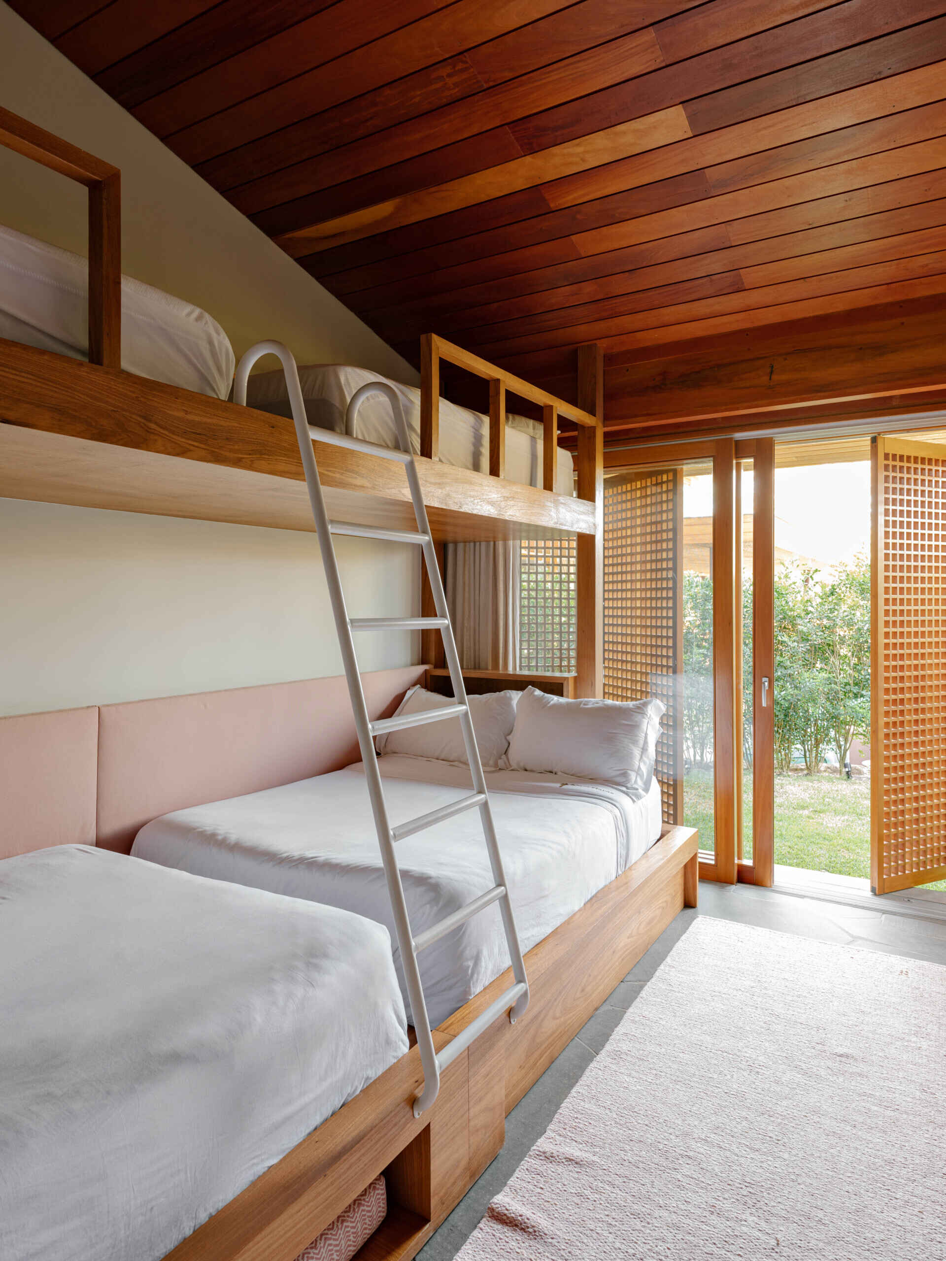 Among the home's bedrooms is a dedicated bunk room that provides extra sleeping space for children and visiting friends, while a sliding door and moveable screens connect the room to the outdoors.