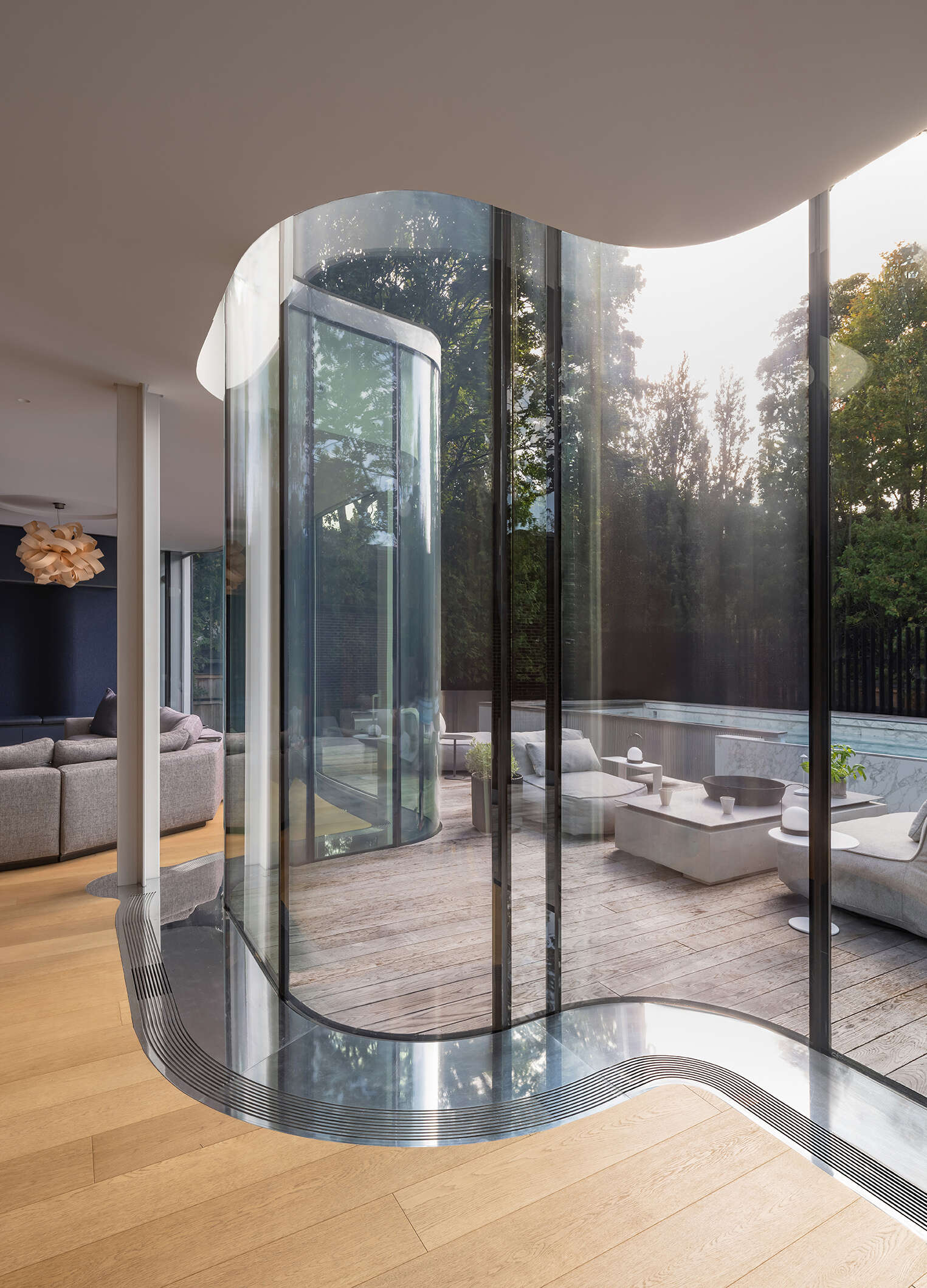The flowing curved glass wall is the signature feature of Snider House, bringing light, transparency, and garden views deep into the home.