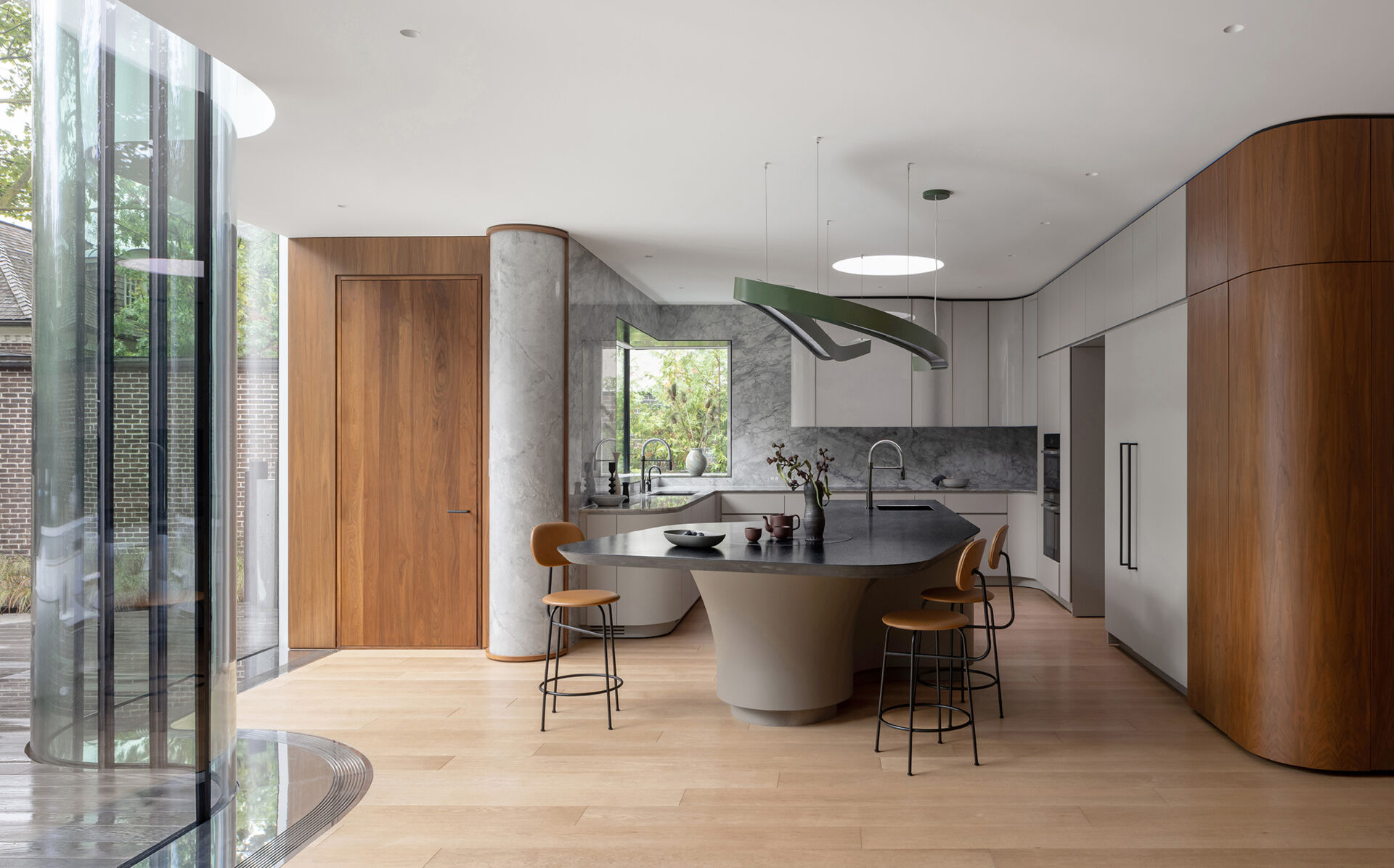 This Toronto kitchen combines marble, walnut, skylight illumination, and a sculptural custom chandelier in a beautifully luminous space.