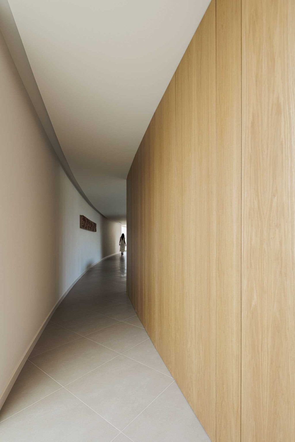 A graceful curved hallway links the bedrooms while extending the home's signature architectural form throughout the upper level.