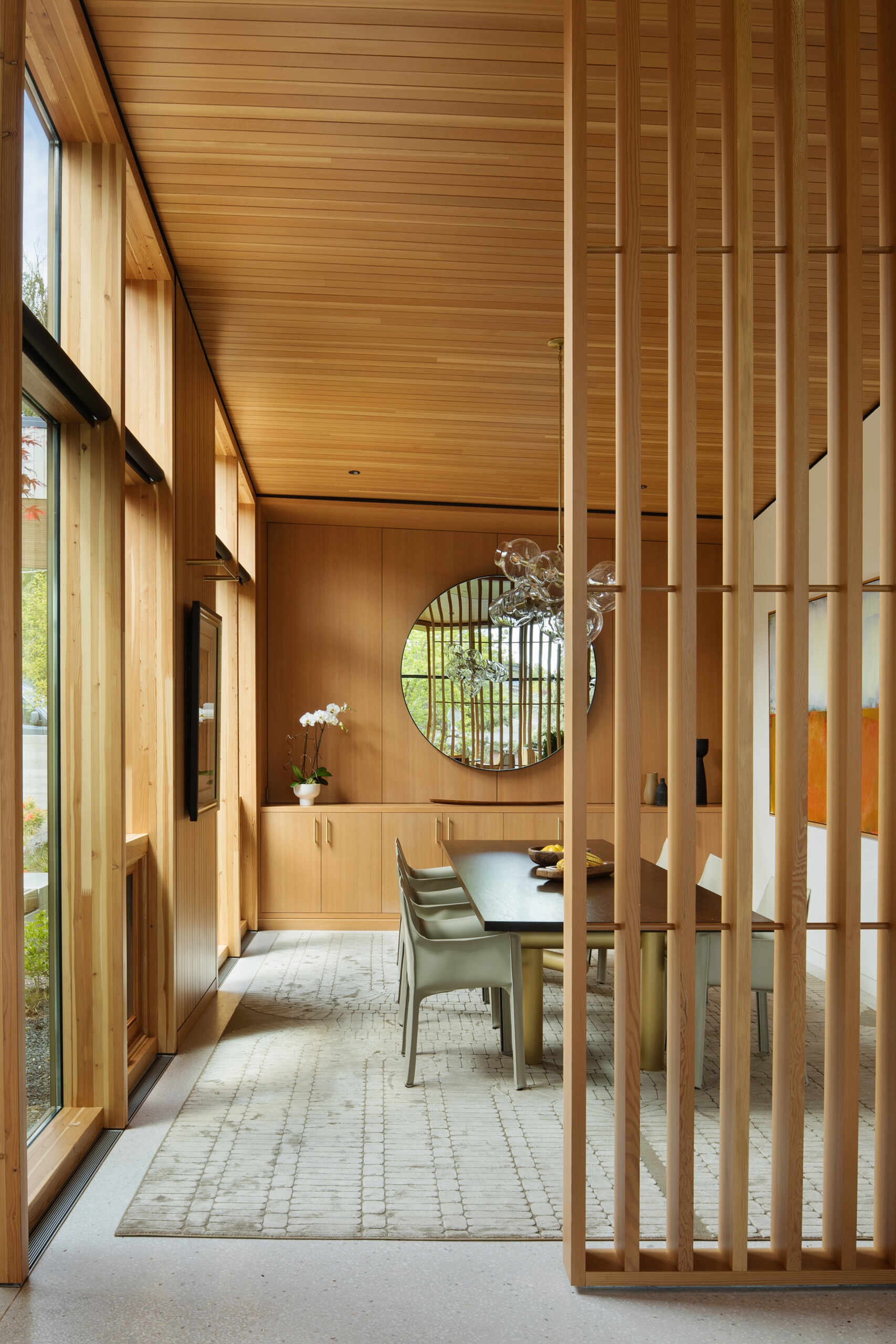 Eche un vistazo al interior del cálido comedor de madera, donde las altas ventanas, la suave luz natural y los elegantes acabados crean el ambiente perfecto para cenar y entretenerse todos los días.