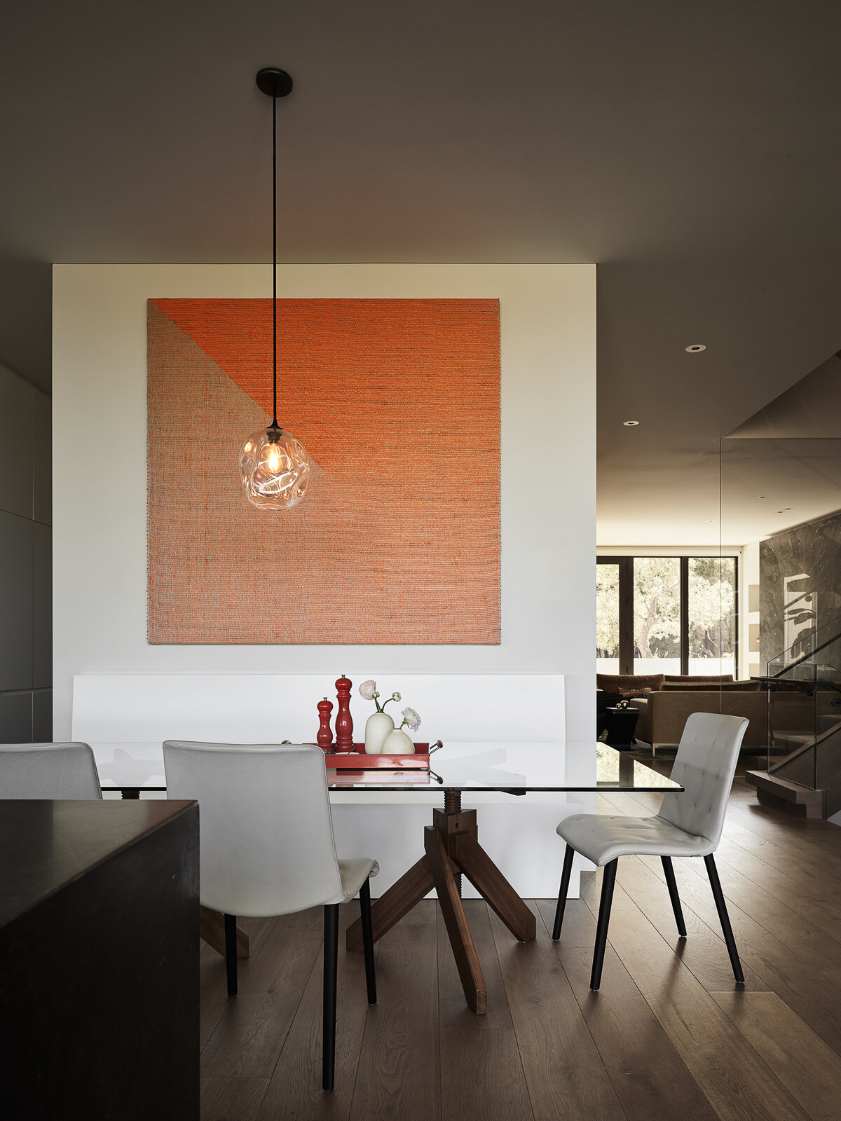 A glowing pendant, contemporary furnishings, and vibrant artwork bring warmth to this modern dining room. Discover how color, natural light, and sculptural design create a welcoming space for everyday meals and entertaining.