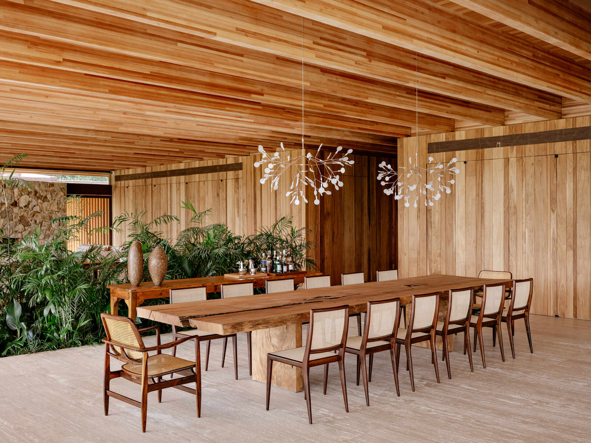 Descubra un comedor contemporáneo con muebles brasileños, cálidos techos de madera y conexiones perfectas entre el interior y el exterior.