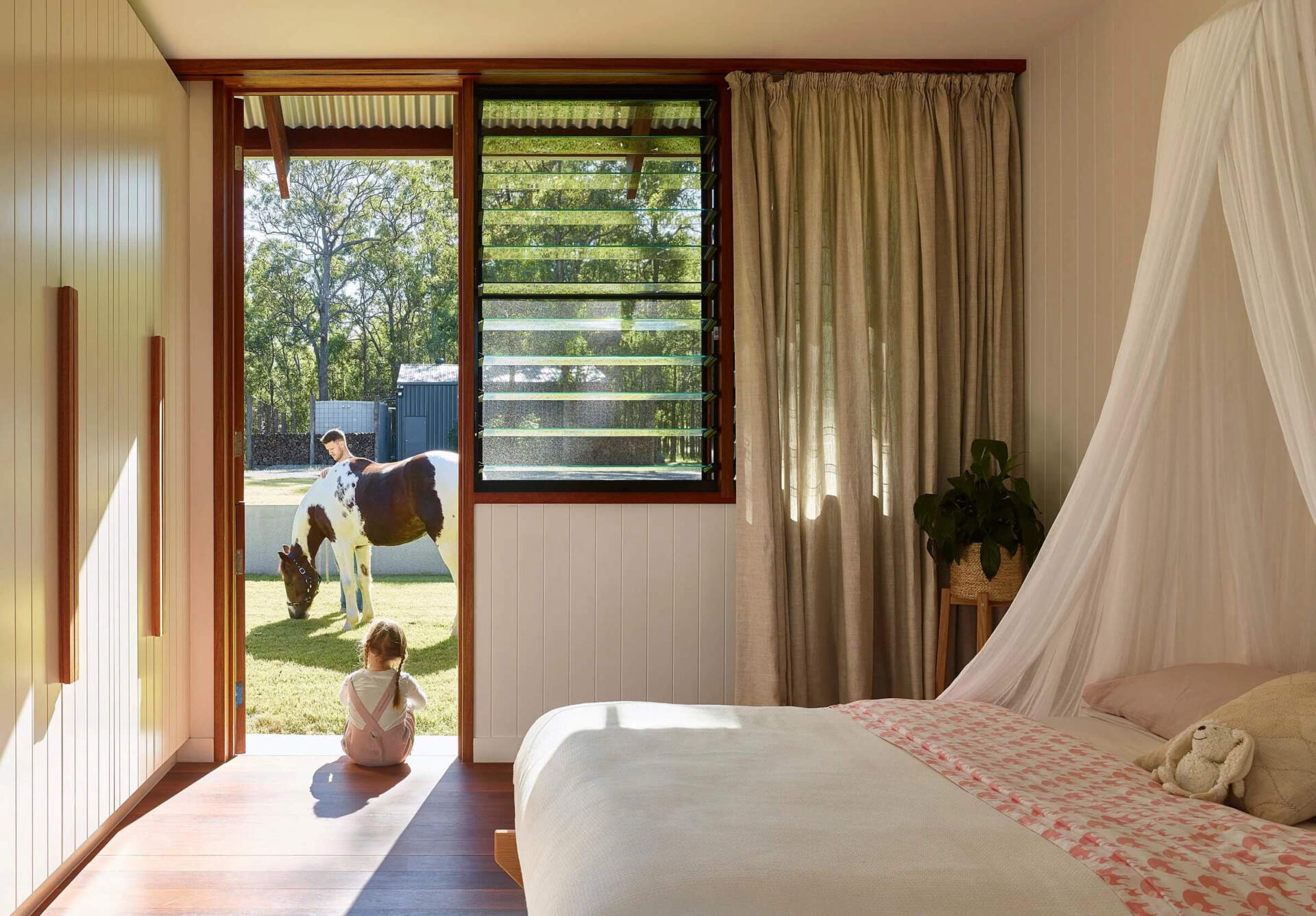 This bedroom includes charming Dutch door that introduce a subtle farm-inspired detail. They add personality while fitting naturally with the relaxed character of the home.
