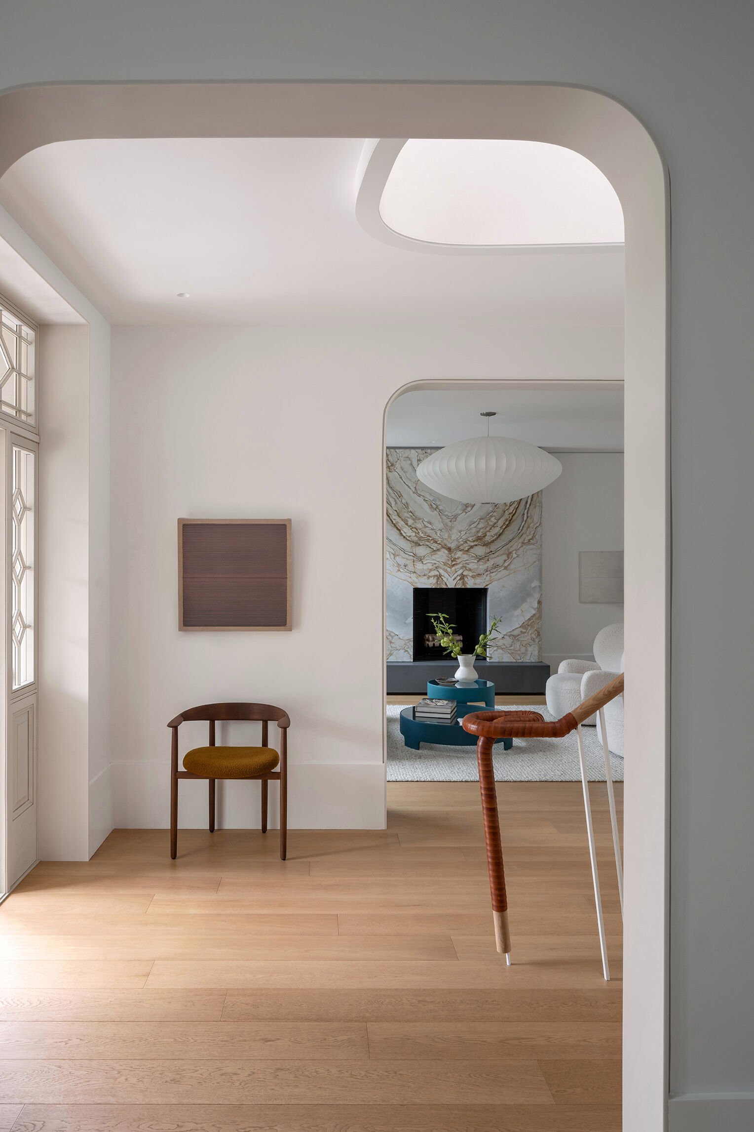 Discover the restored living room with its curved marble fireplace, contemporary furnishings, and modern lighting inside Snider House.