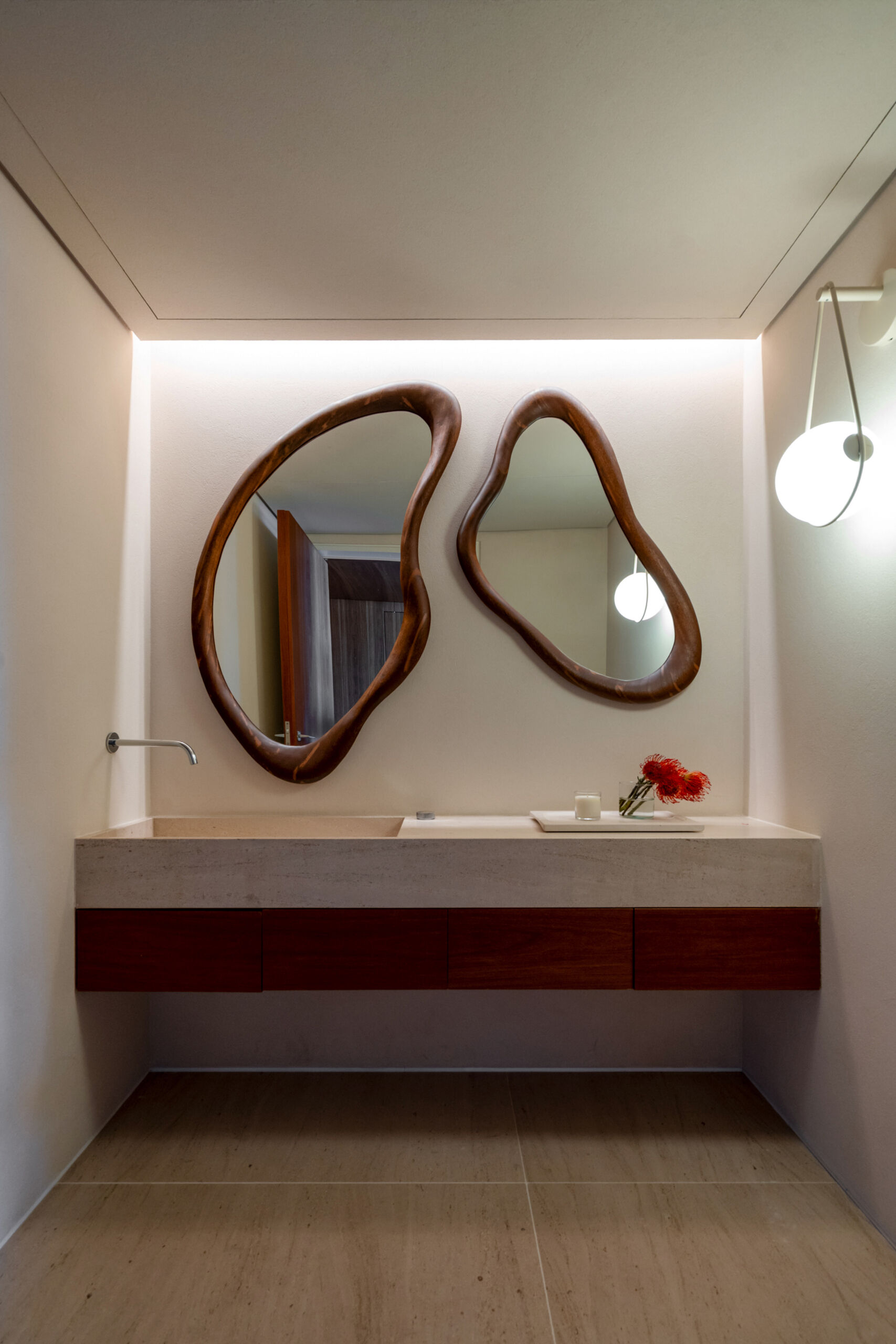 Stone surfaces, organic mirrors and understated lighting give the guest bathrooms a clean, timeless appearance.