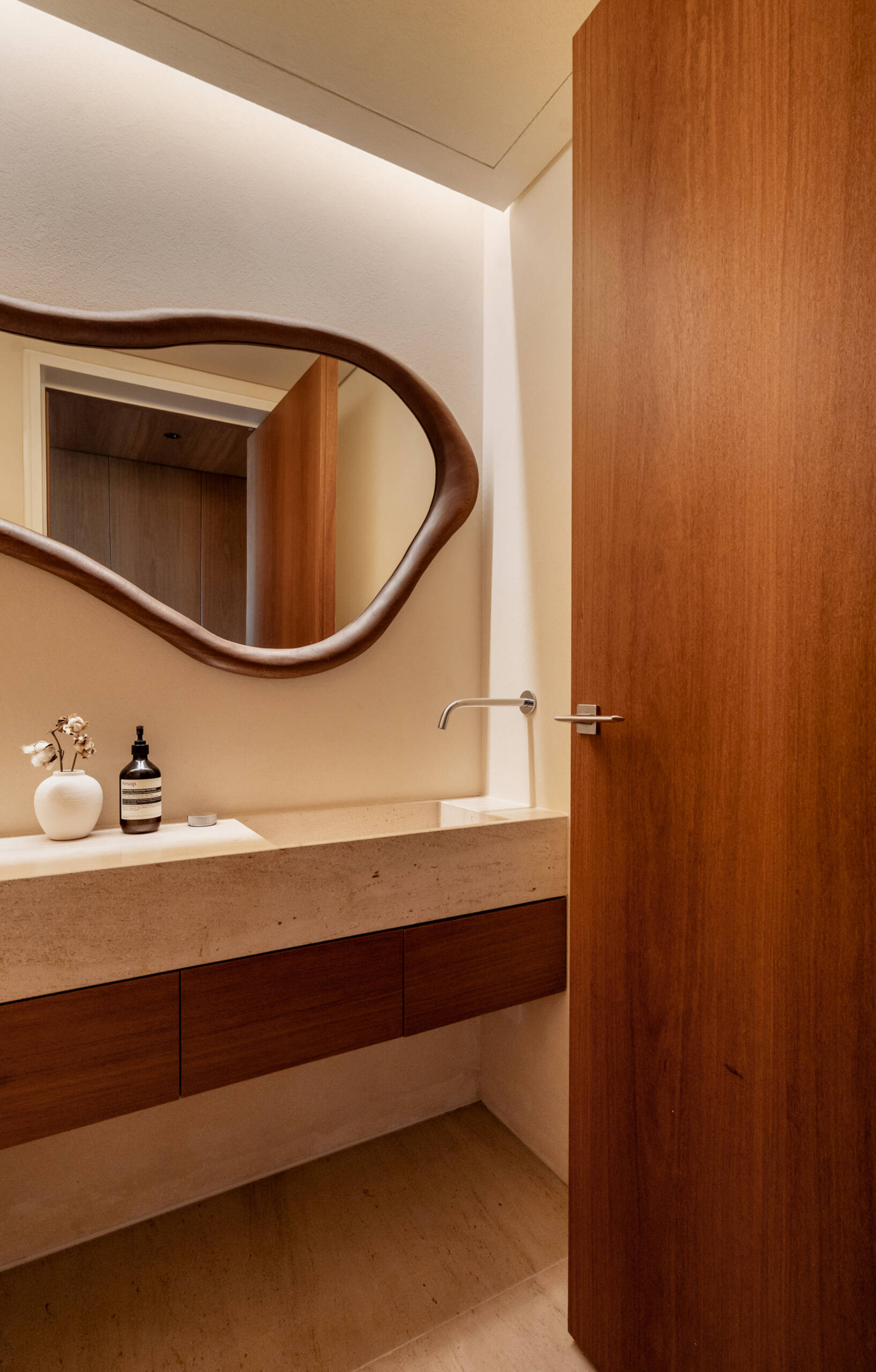 Stone surfaces, organic mirrors and understated lighting give the guest bathrooms a clean, timeless appearance.