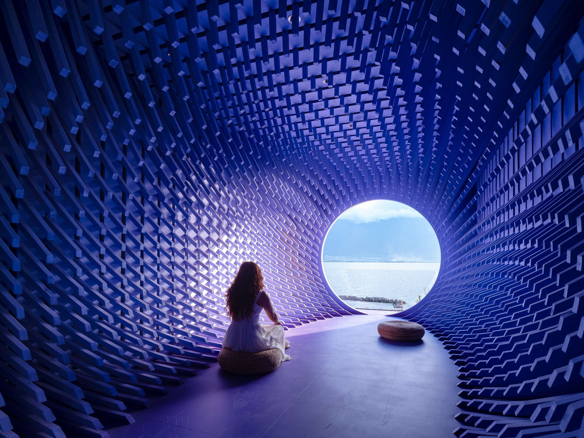 Built from 999 stacked pine timbers, the Moon Suite frames the mountains, lake and moon through a large circular opening that becomes the room's focal point.