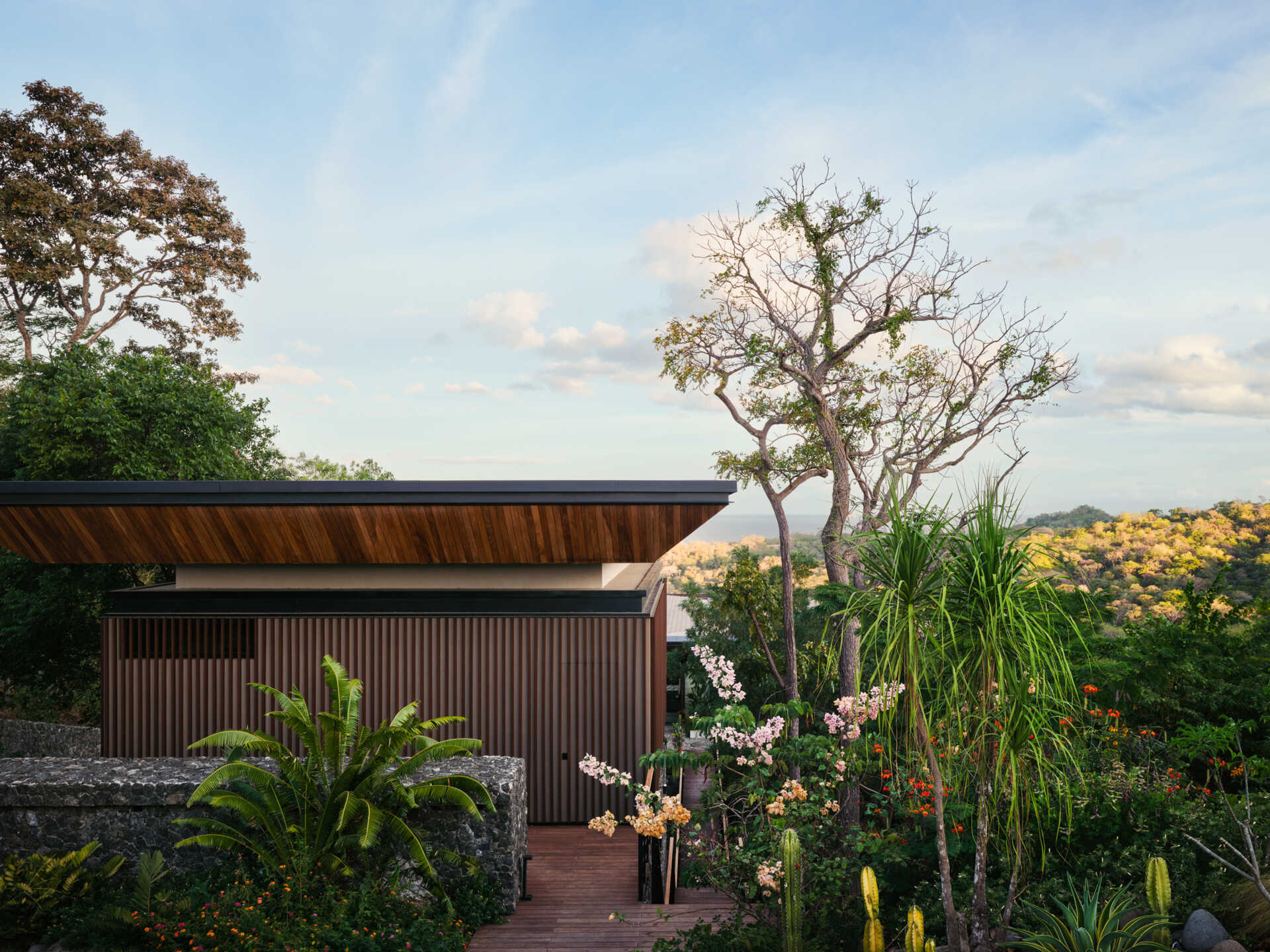 See how Casa Akíga uses stone, timber, and a floating roof to create a modern home shaped by Costa Rica's natural terrain.