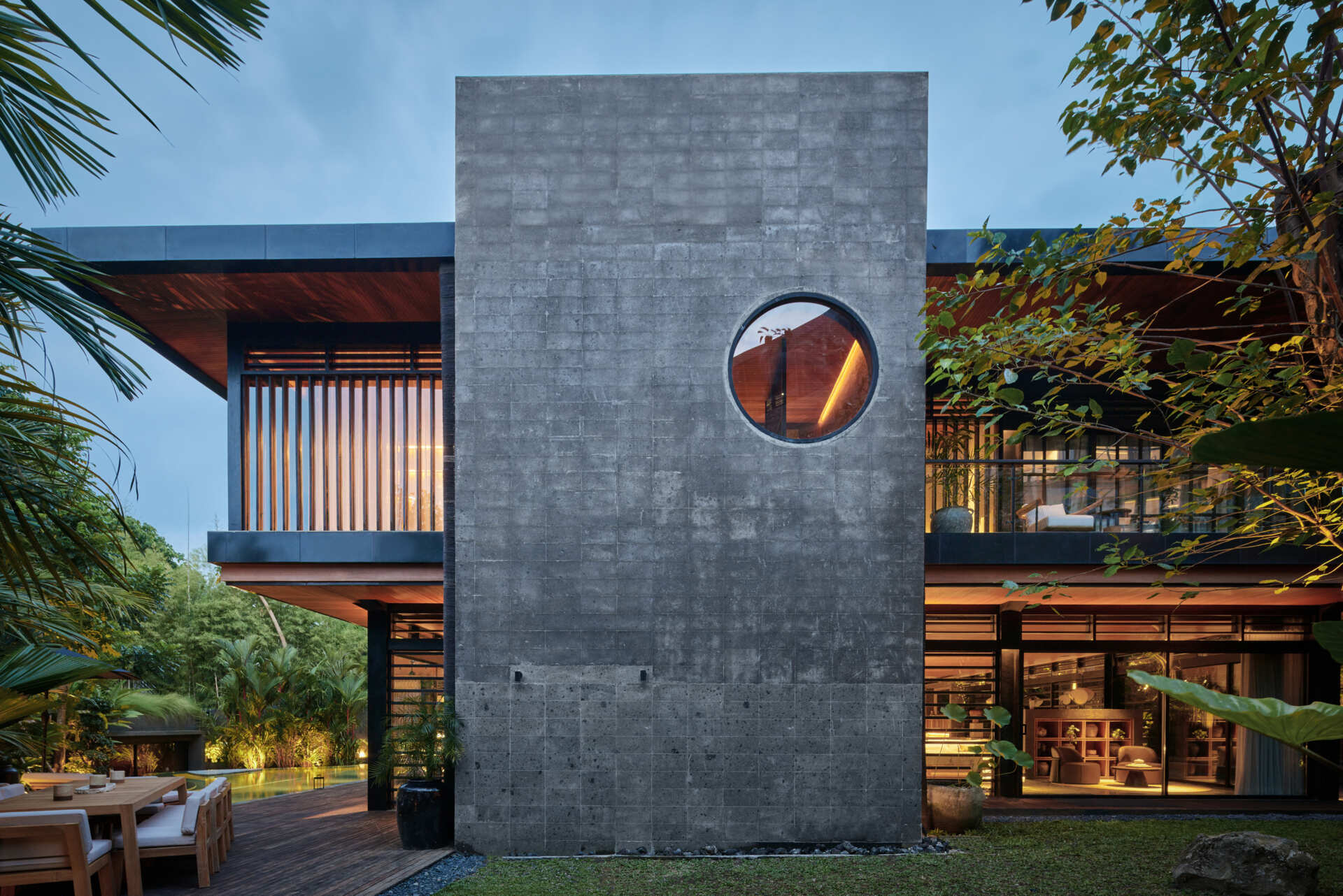 The circular opening inside Villa Suki's volcanic stone staircase is one of the home's most unforgettable architectural details.