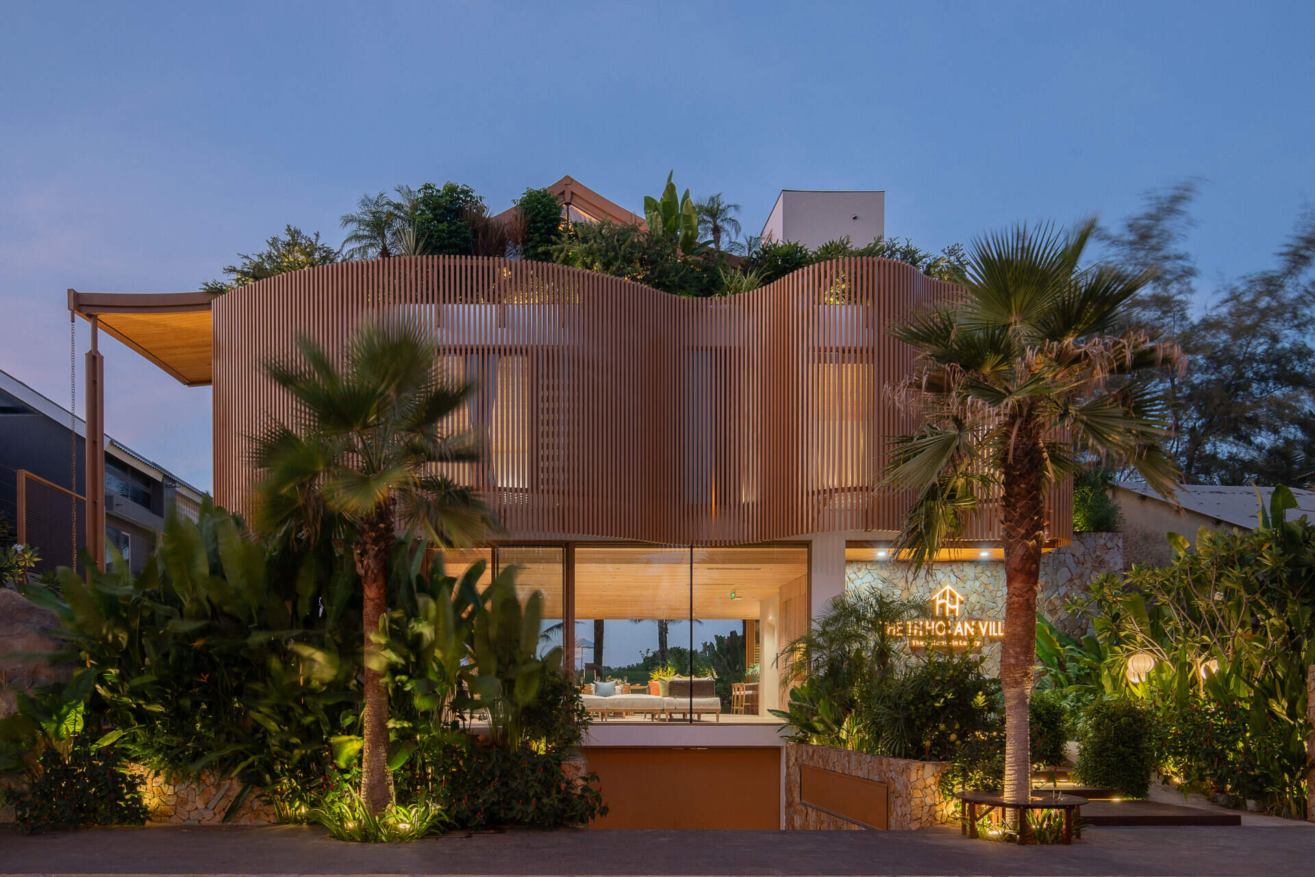The sculptural façade, basement garage and wave-inspired louver system give TH Villa Hoi An a distinctive coastal identity while responding to the tropical climate.