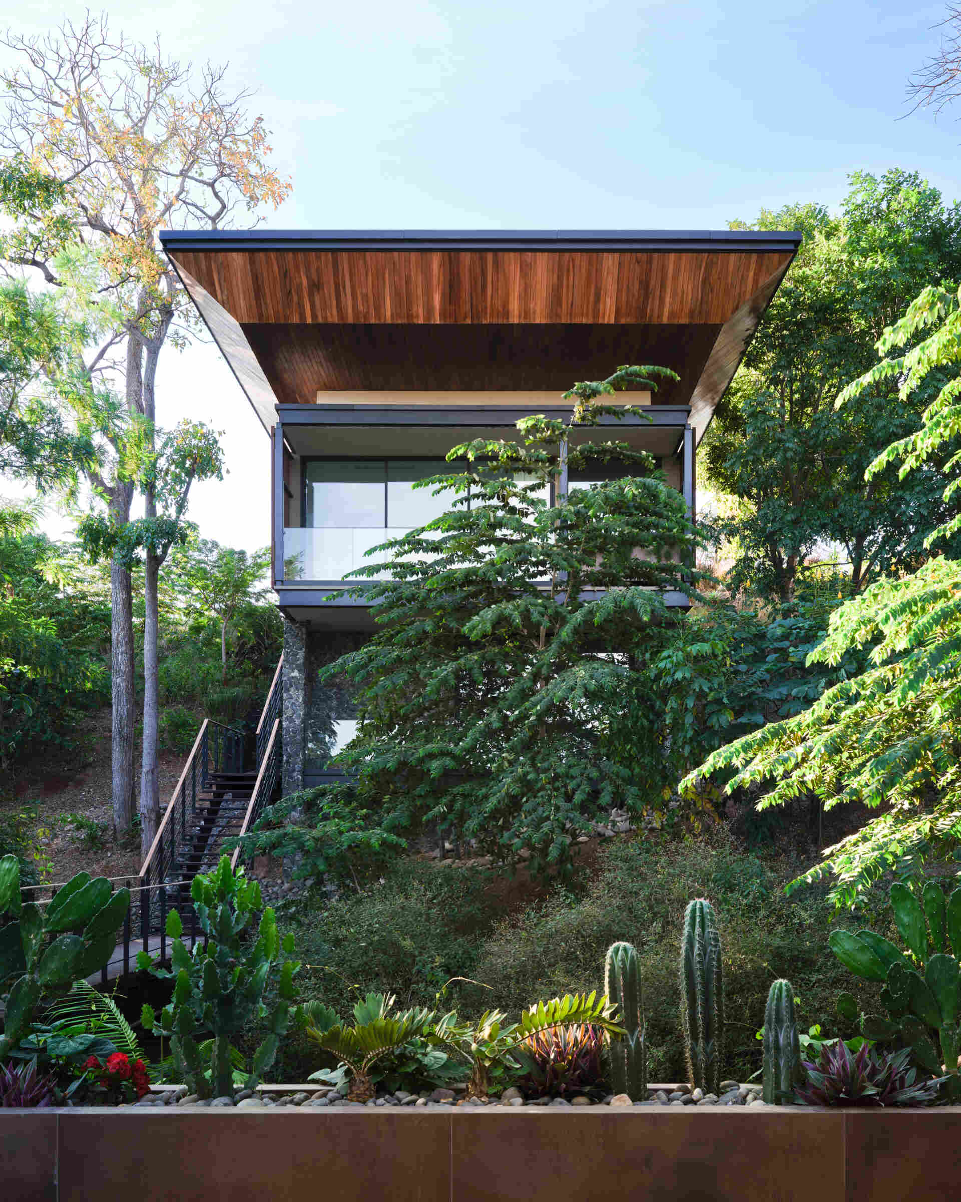 See how Casa Akíga uses stone, timber, and a floating roof to create a modern home shaped by Costa Rica's natural terrain.