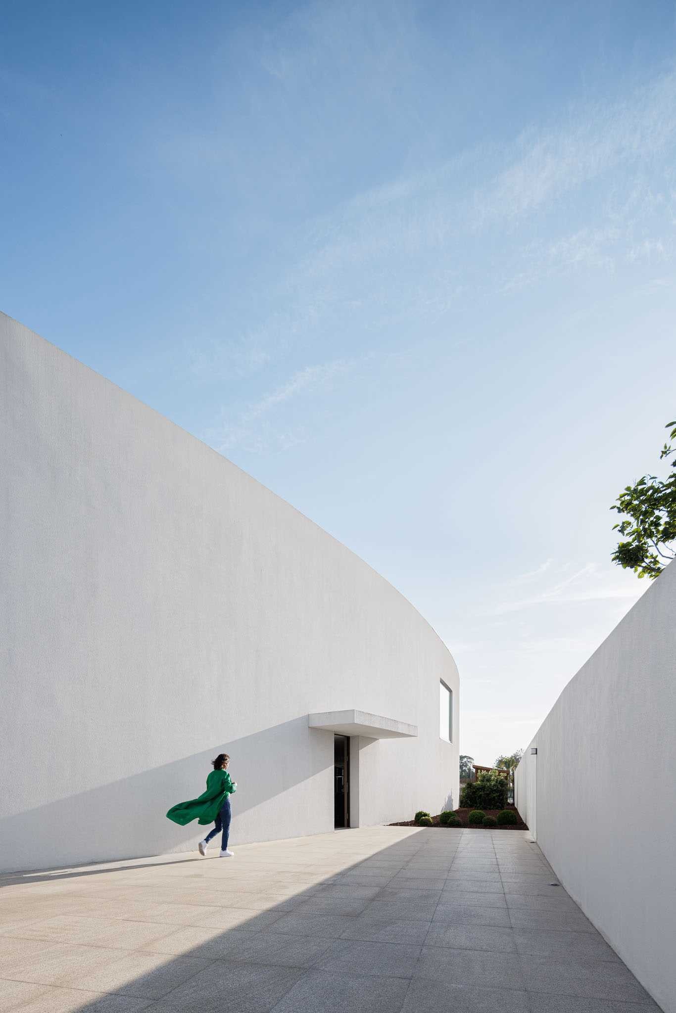 A striking curved home in Vagos, Portugal, by FRARI – architecture network transforms a challenging roadside site into a bright and private modern residence.