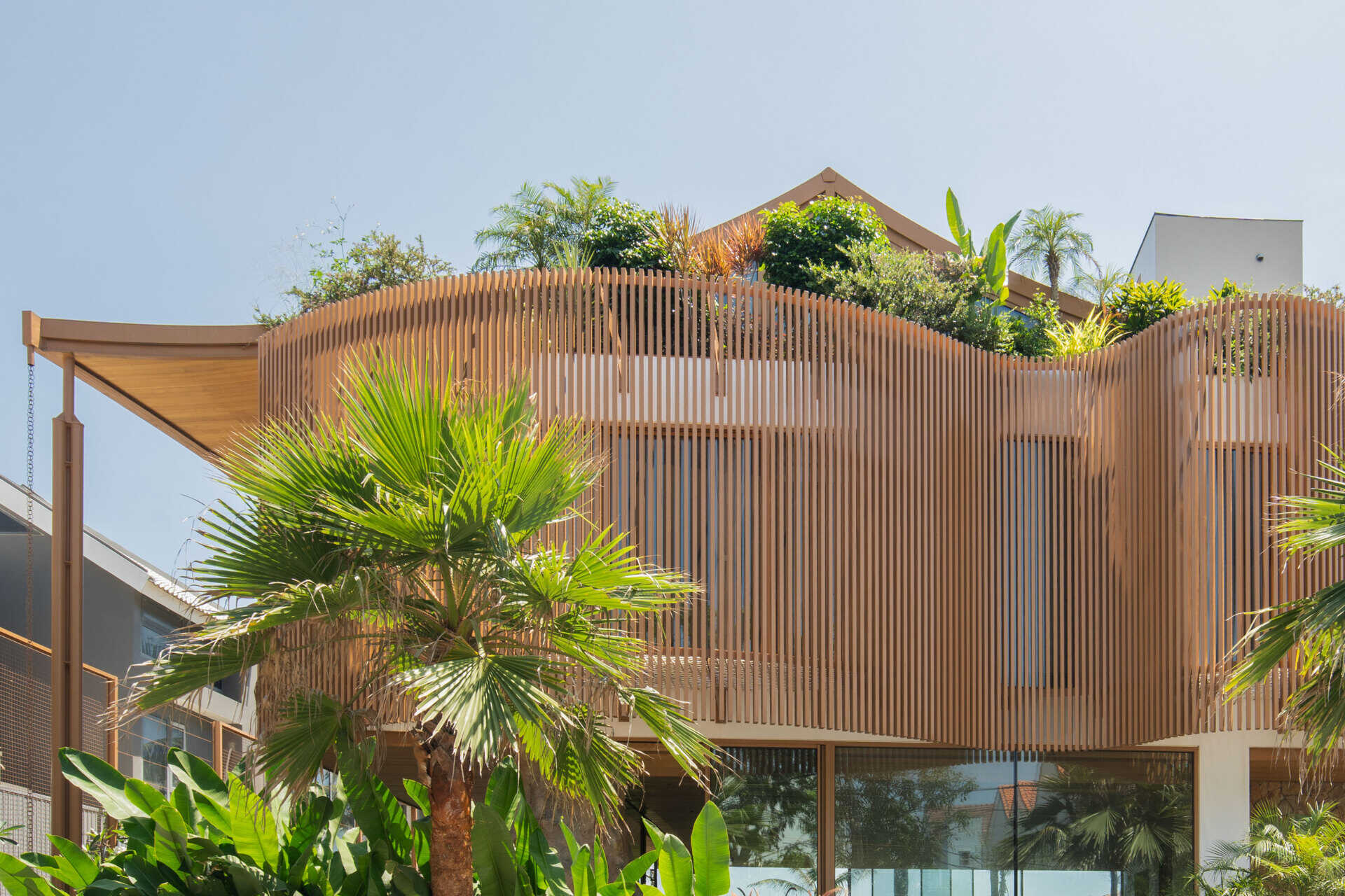 The sculptural façade, basement garage and wave-inspired louver system give TH Villa Hoi An a distinctive coastal identity while responding to the tropical climate.