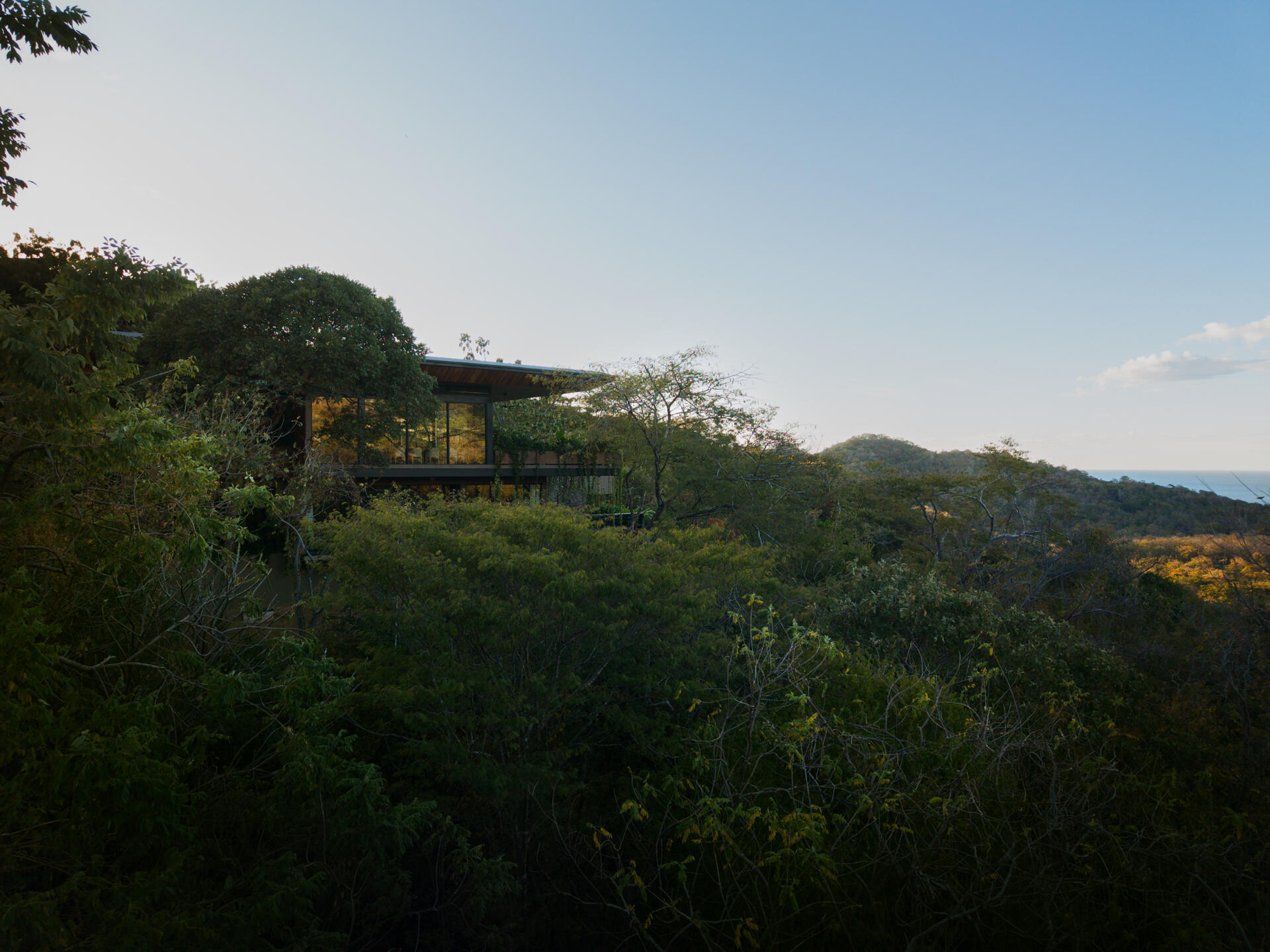 See how Casa Akíga uses stone, timber, and a floating roof to create a modern home shaped by Costa Rica's natural terrain.
