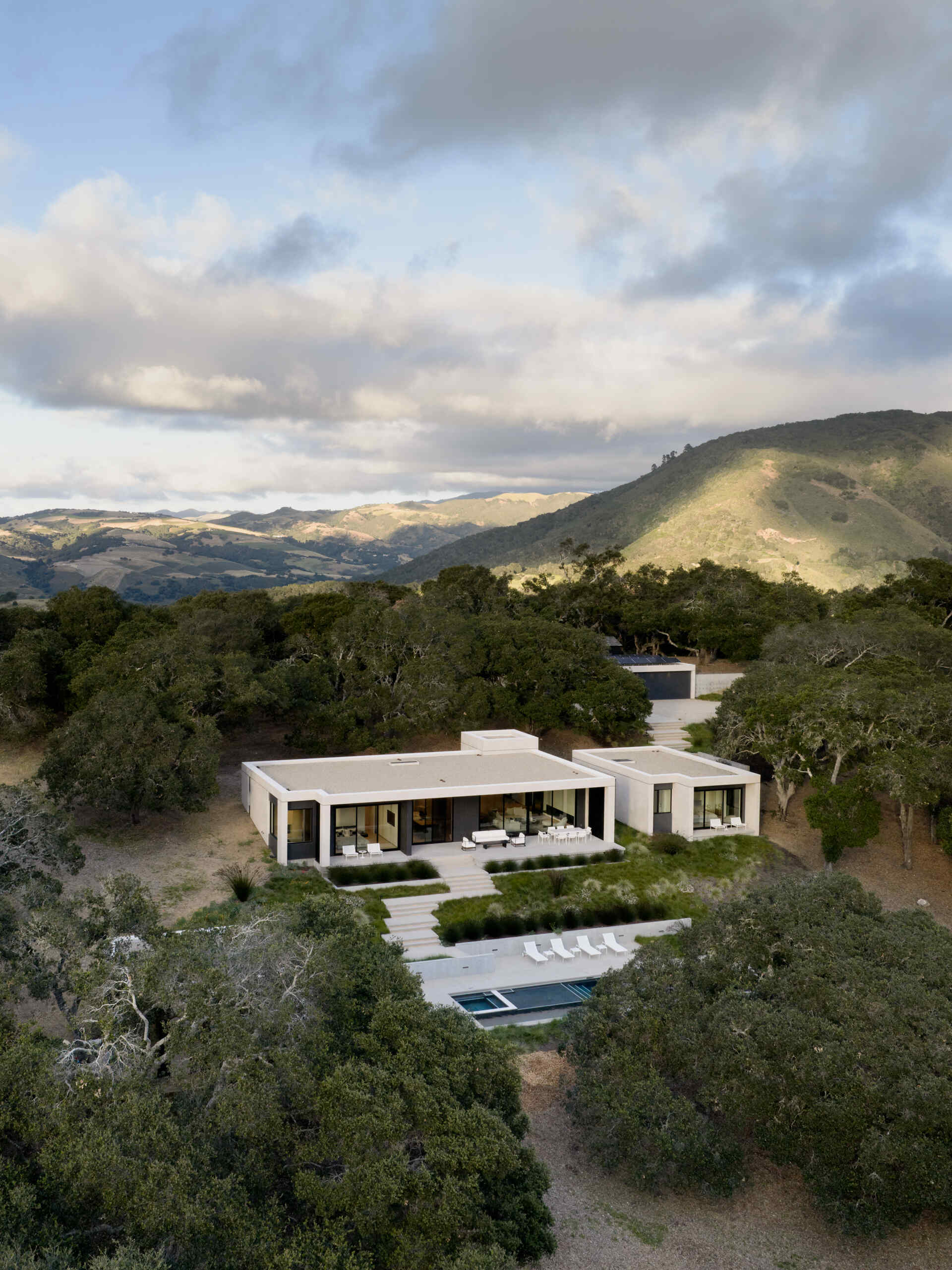 Vea cómo Live Oak Residence se integra con las praderas de California al estar ubicada bajo una ladera y frente a amplias vistas.