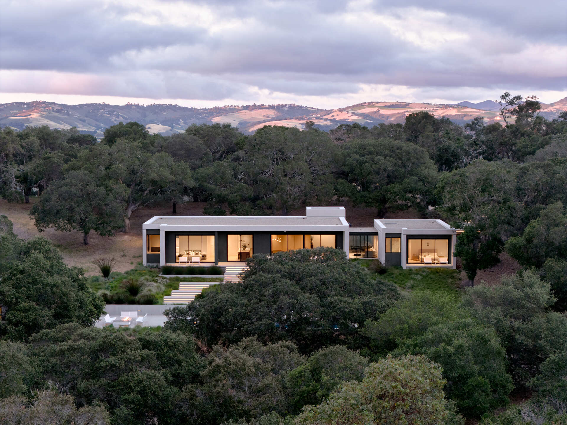 Vea cómo Live Oak Residence se integra con las praderas de California al estar ubicada bajo una ladera y frente a amplias vistas.