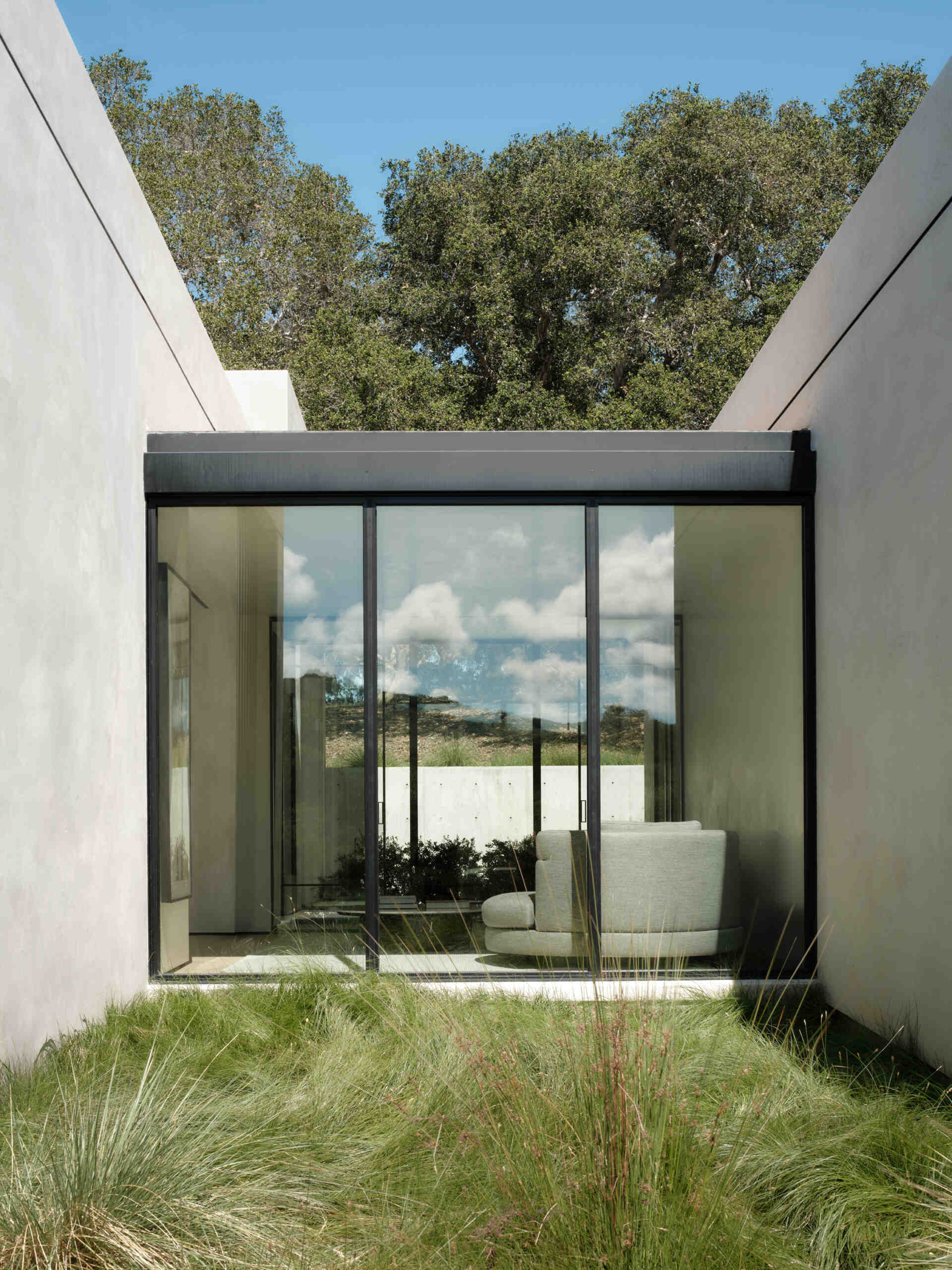 Los grandes ventanales transforman el paisaje de California en arte vivo en todo Live Oak Residence.