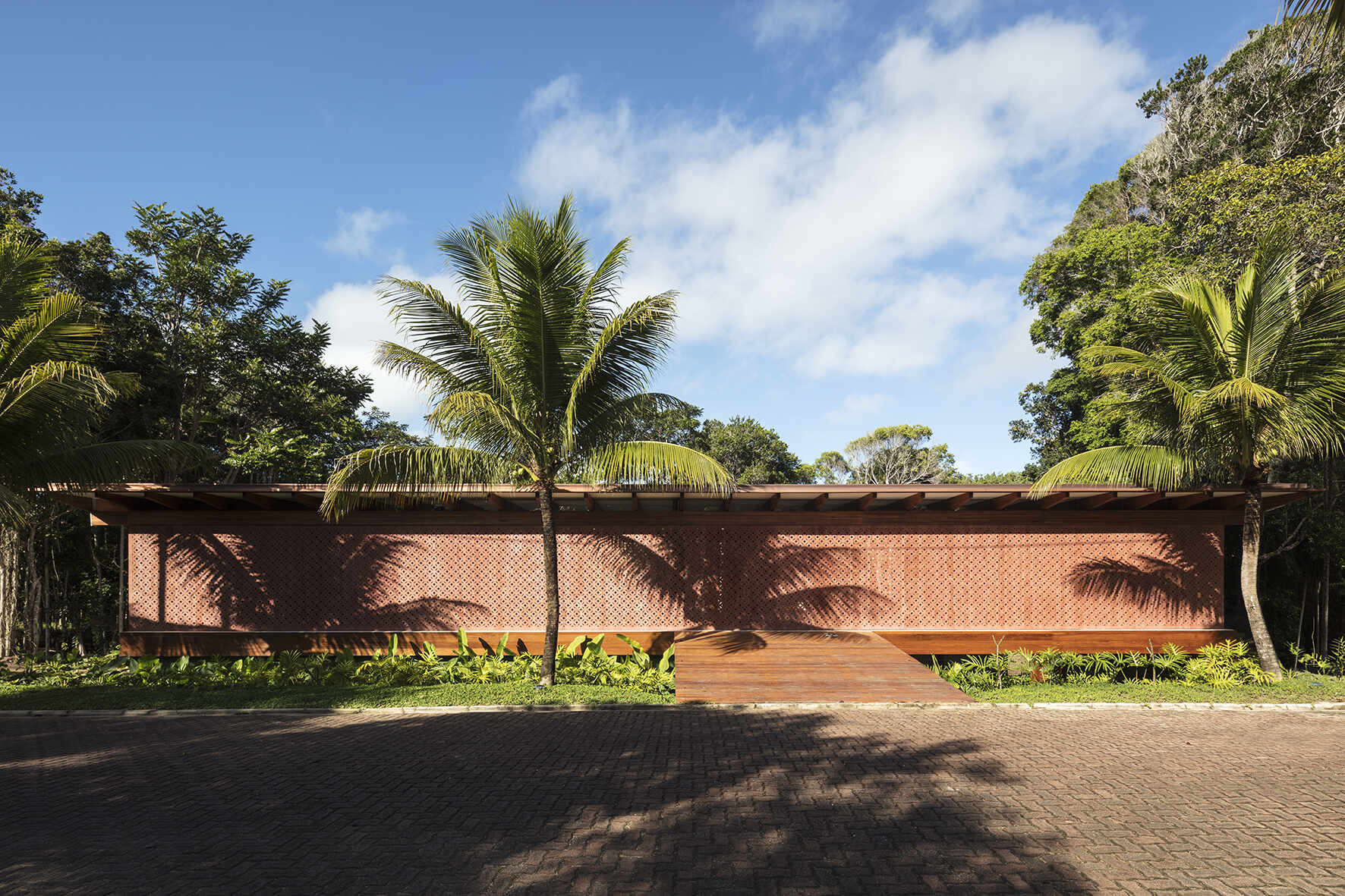 Take a tour of Muxarabi House in Trancoso, Brazil, where eucalyptus timber, handcrafted interiors, geometric façade screens and a rooftop garden come together in one contemporary beach home.