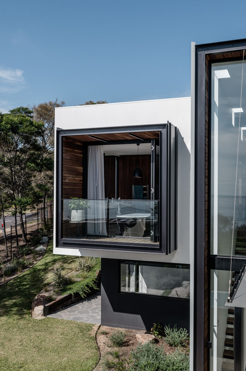 Una bañera independiente, un balcón privado de madera y vistas panorámicas transforman este moderno baño en un espacio excepcional.