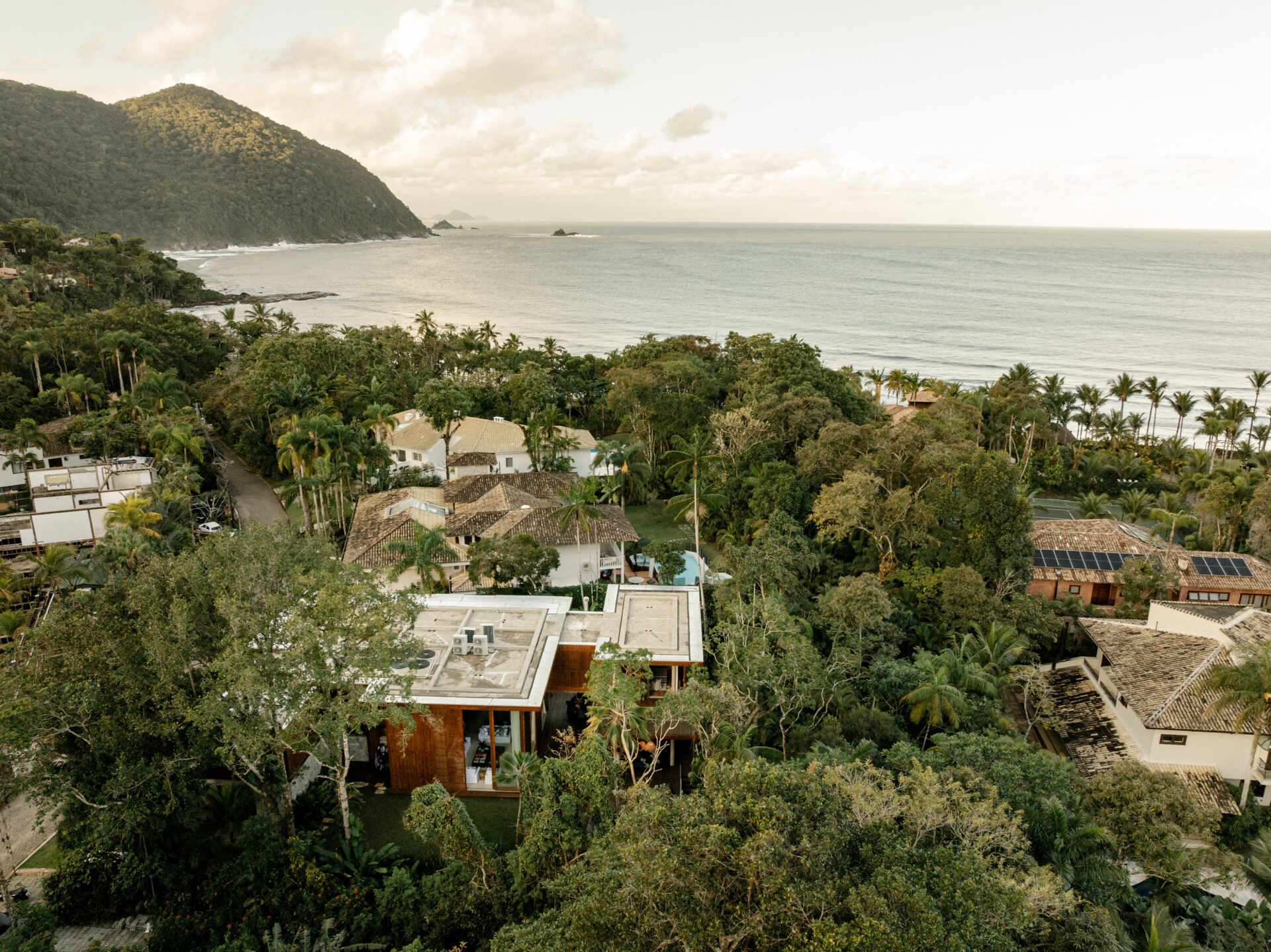 Discover how stone, timber, glass, and clean architectural lines give this Brazilian beach house its timeless street appeal.