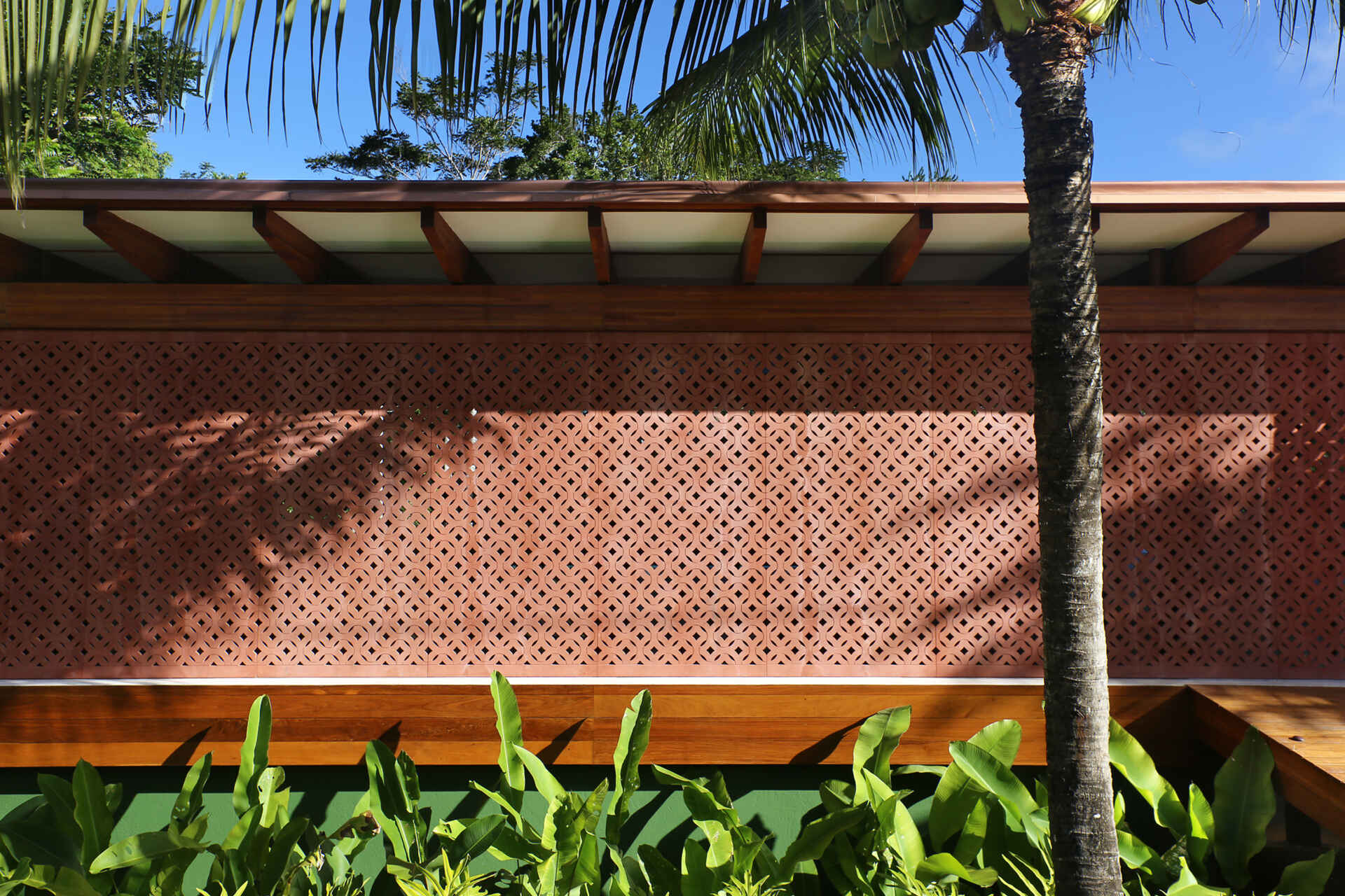 Take a tour of Muxarabi House in Trancoso, Brazil, where eucalyptus timber, handcrafted interiors, geometric façade screens and a rooftop garden come together in one contemporary beach home.
