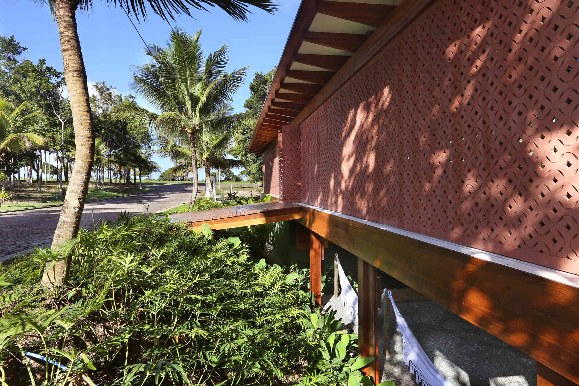 Take a tour of Muxarabi House in Trancoso, Brazil, where eucalyptus timber, handcrafted interiors, geometric façade screens and a rooftop garden come together in one contemporary beach home.