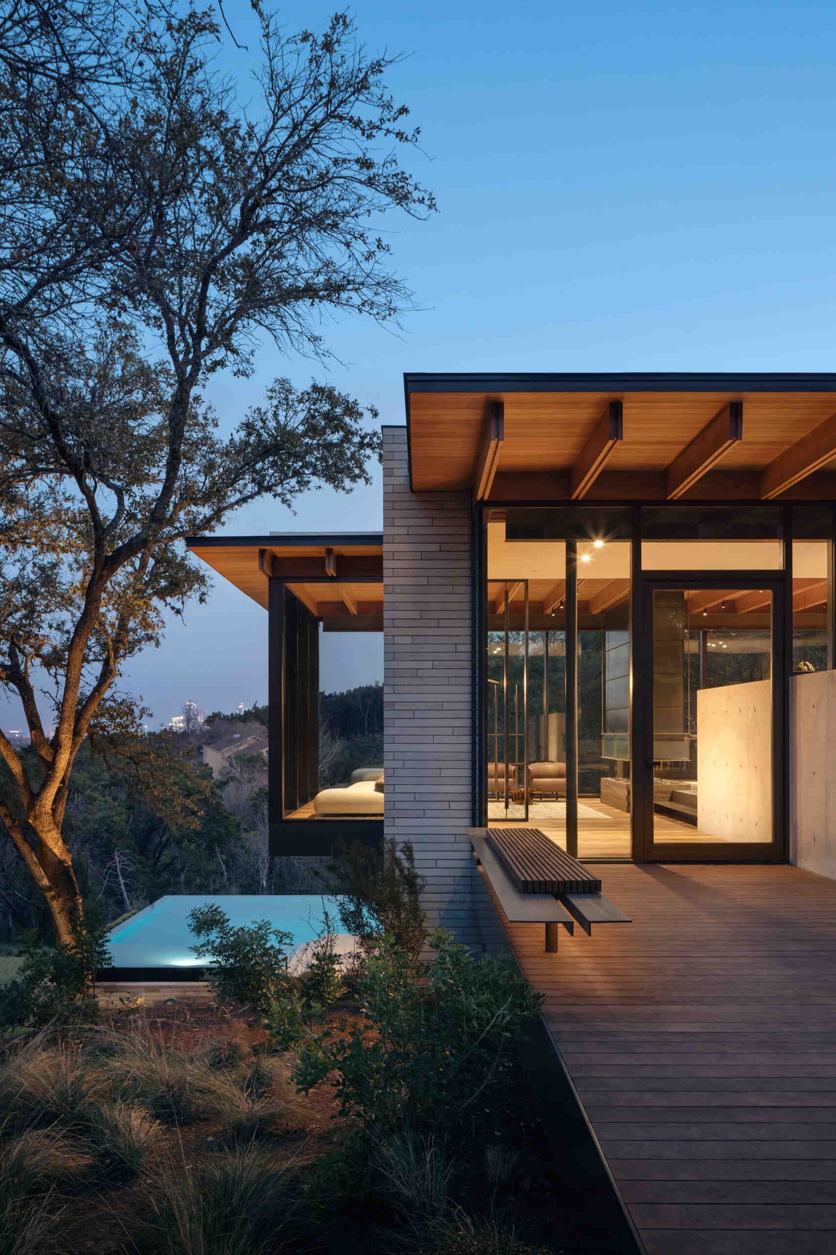 A pedestrian bridge creates a memorable entrance while revealing the home's layered architectural design.