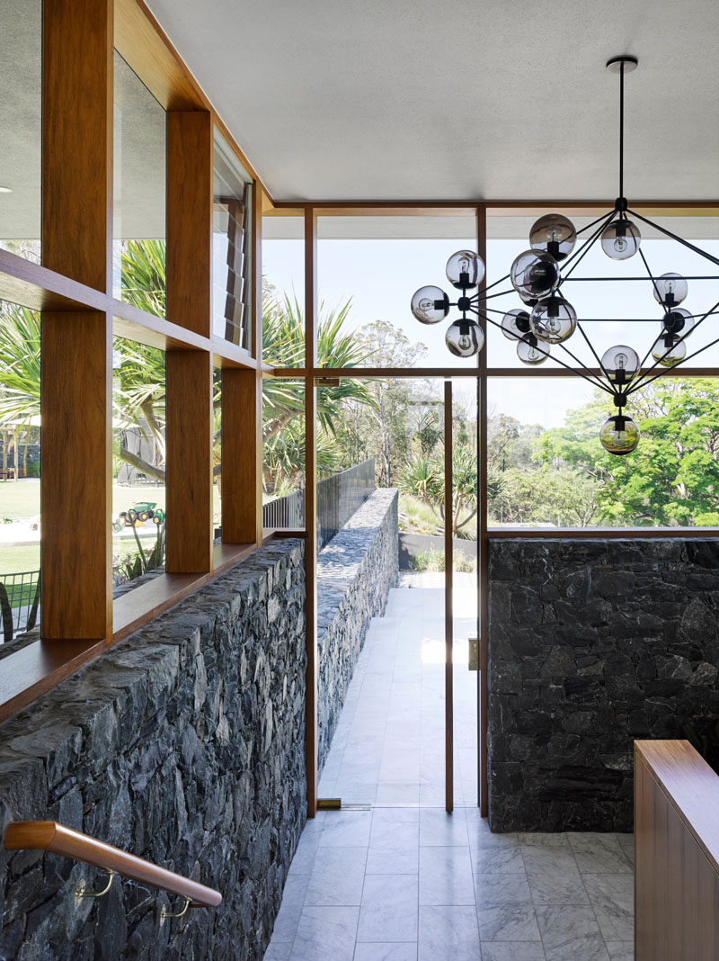 Carrara marble floors and timber-framed windows bring warmth and brightness to this modern Australian interior.