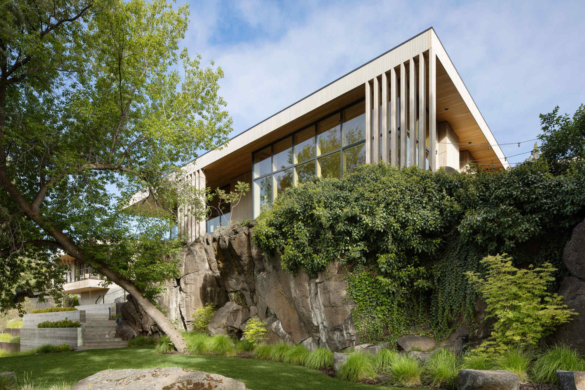 Arquitectura + Materiales exteriores Explore el sorprendente exterior de Riverfold House, que incluye un espectacular techo abuhardillado, revestimiento de cedro desgastado, abeto Douglas y diseños inspirados en el paisaje accidentado del centro de Oregón.