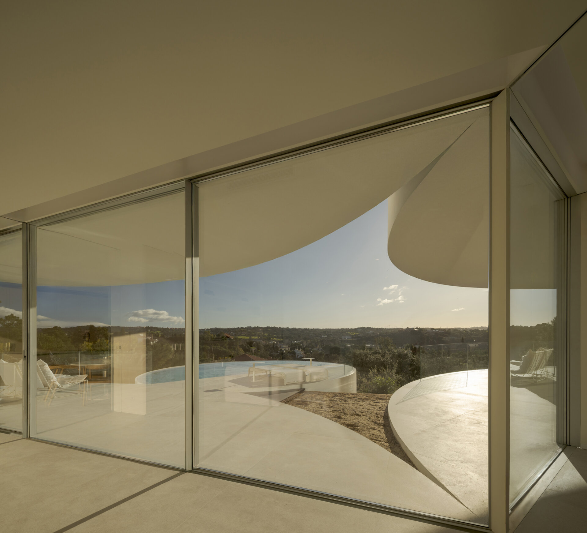 Large glass walls frame spectacular views of the Sierra de Guadarrama while filling this contemporary home with natural light.