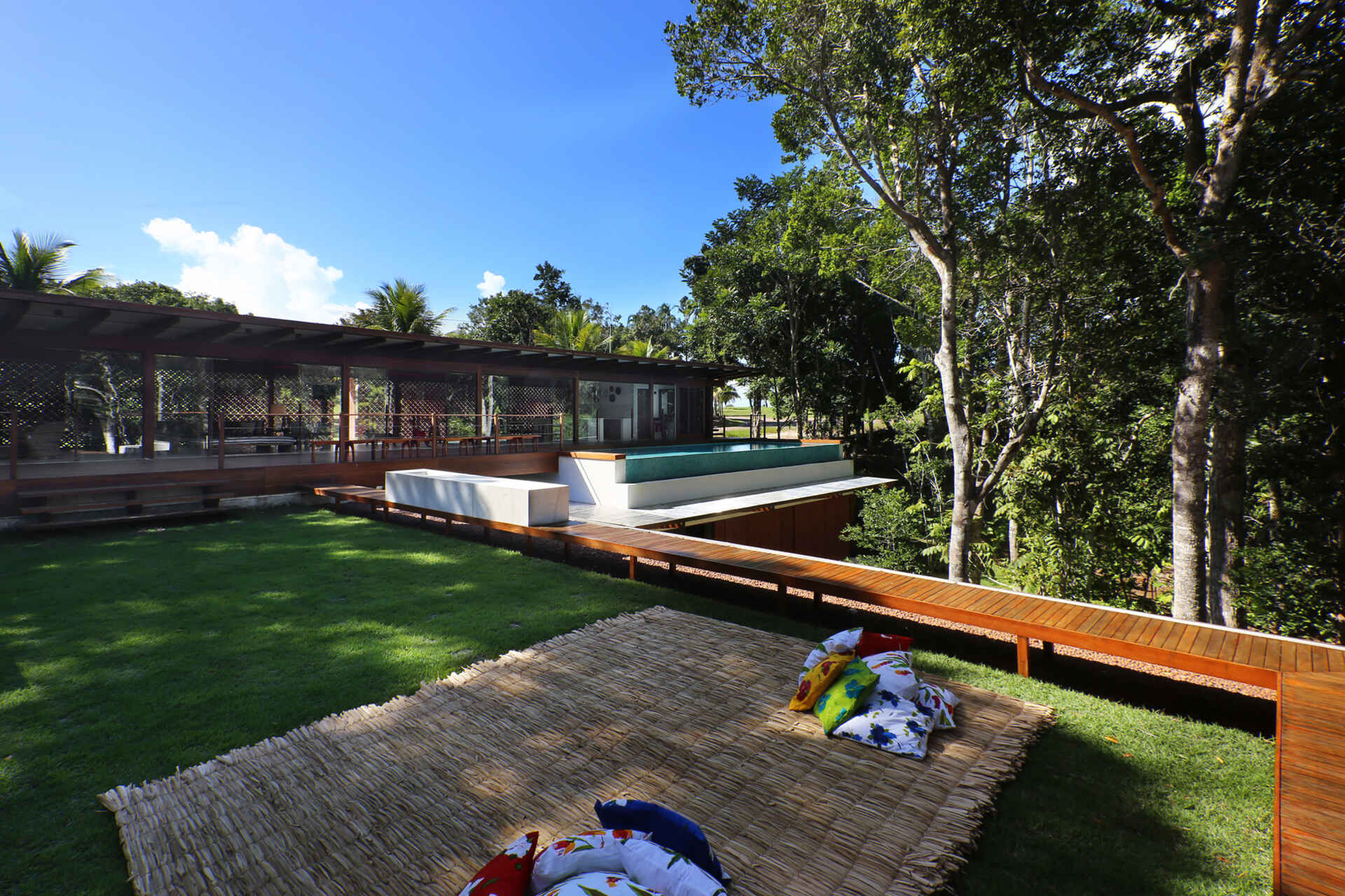 An infinity pool floats above the Atlantic Forest while a generous timber deck and wraparound bench create the perfect outdoor entertaining space.