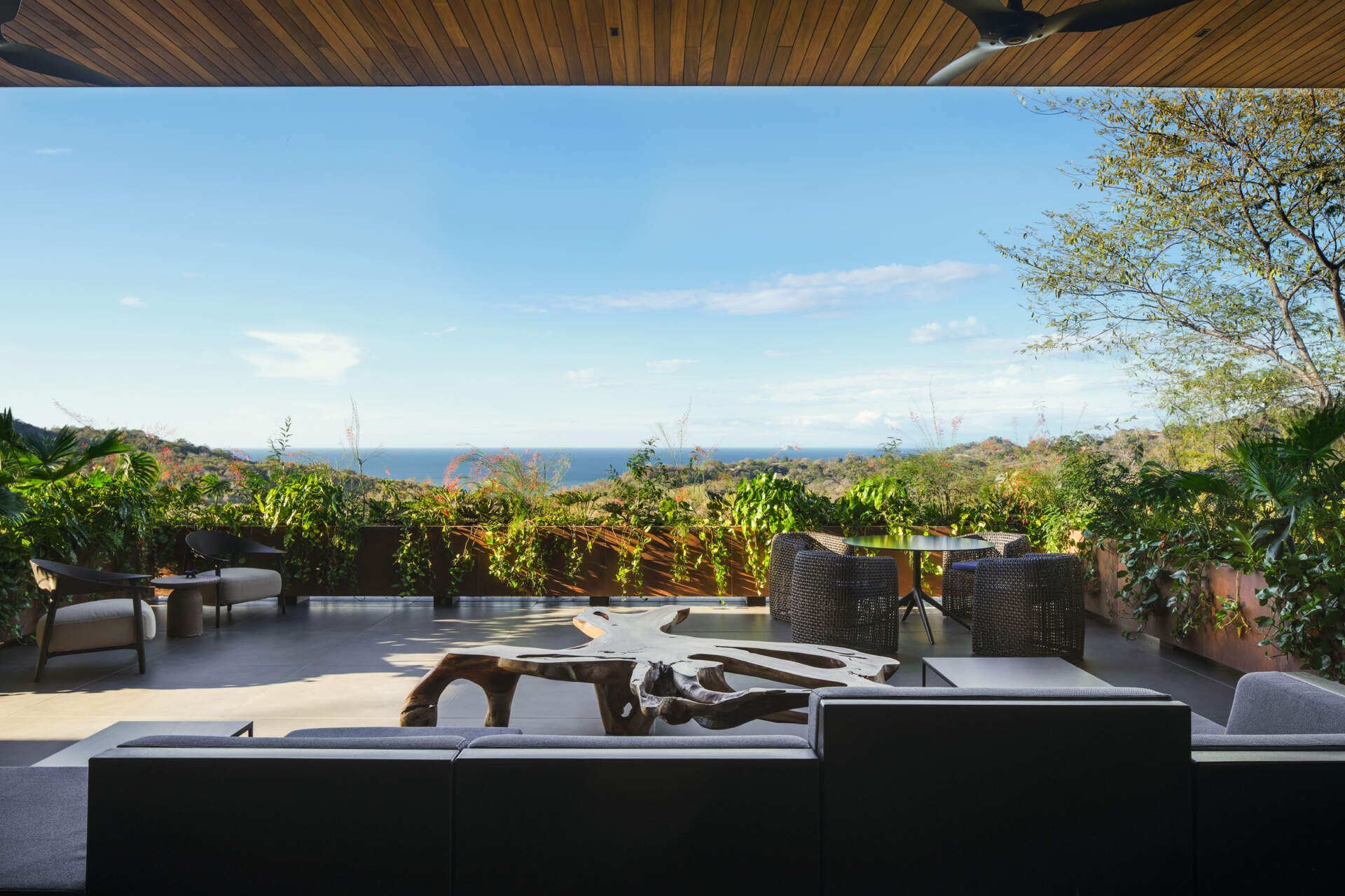 Covered lounges, dining spaces, and sweeping views make this terrace ideal for entertaining in Costa Rica's tropical climate.
