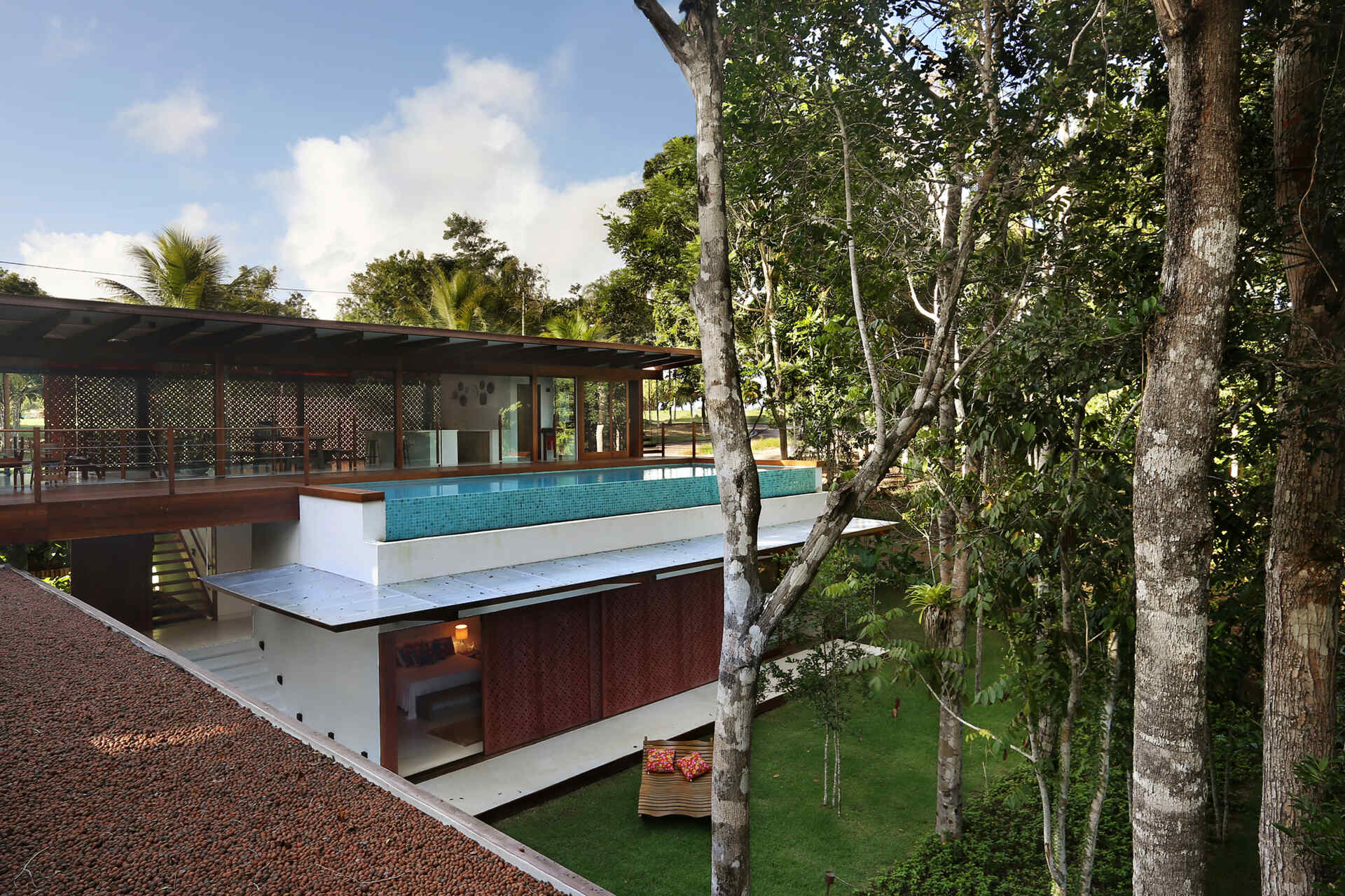 An infinity pool floats above the Atlantic Forest while a generous timber deck and wraparound bench create the perfect outdoor entertaining space.