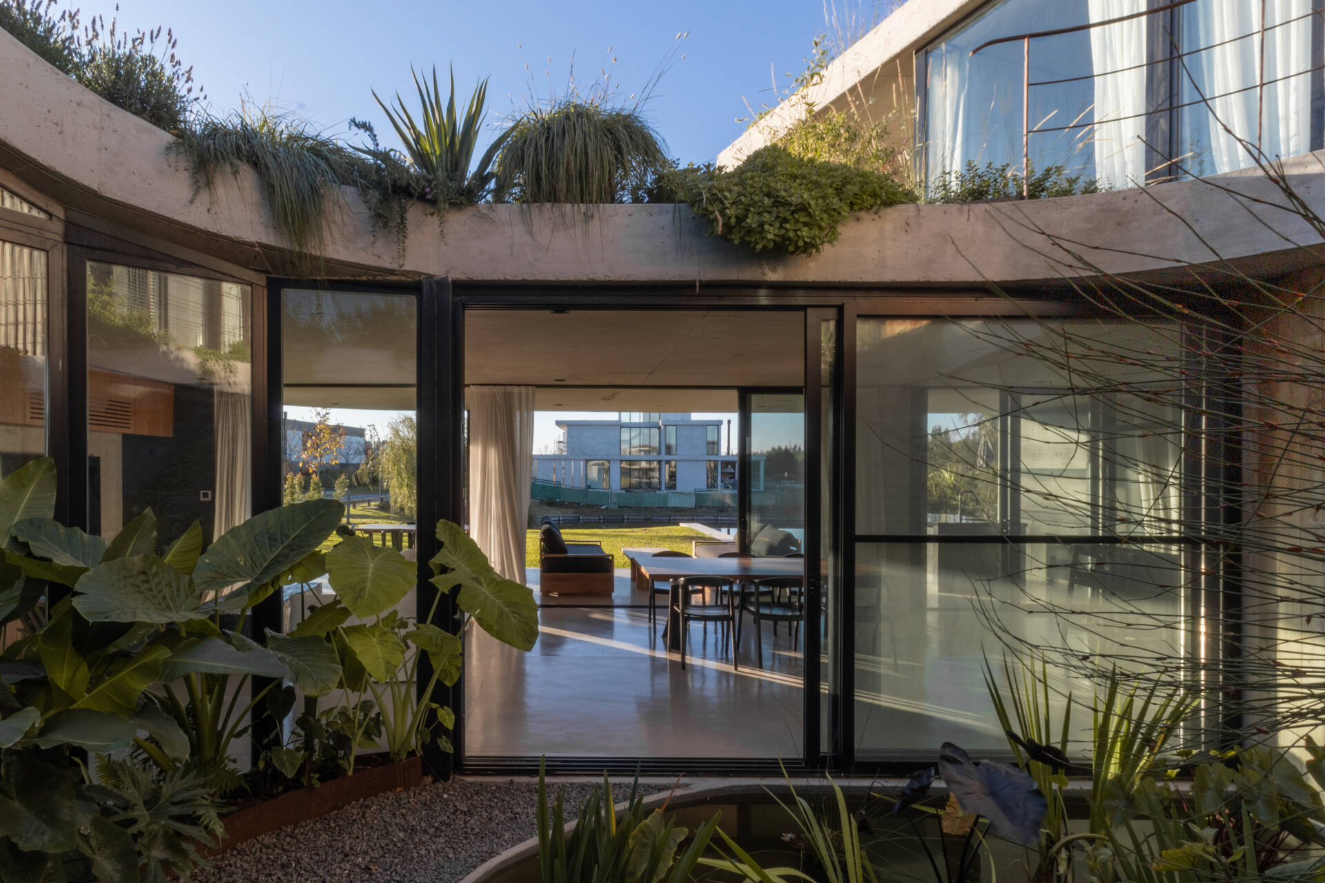 Discover how sliding doors and outdoor stairs connect the home's interiors with a lush rooftop garden overlooking the lagoon.