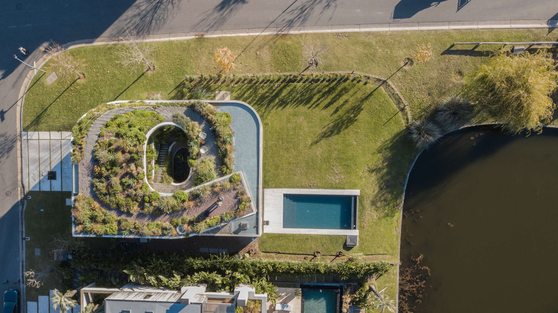 See how GP House by AtelierM transforms two simple curves into an eye-catching spiral home in Buenos Aires, complete with water features, bright interiors, and rooftop gardens.