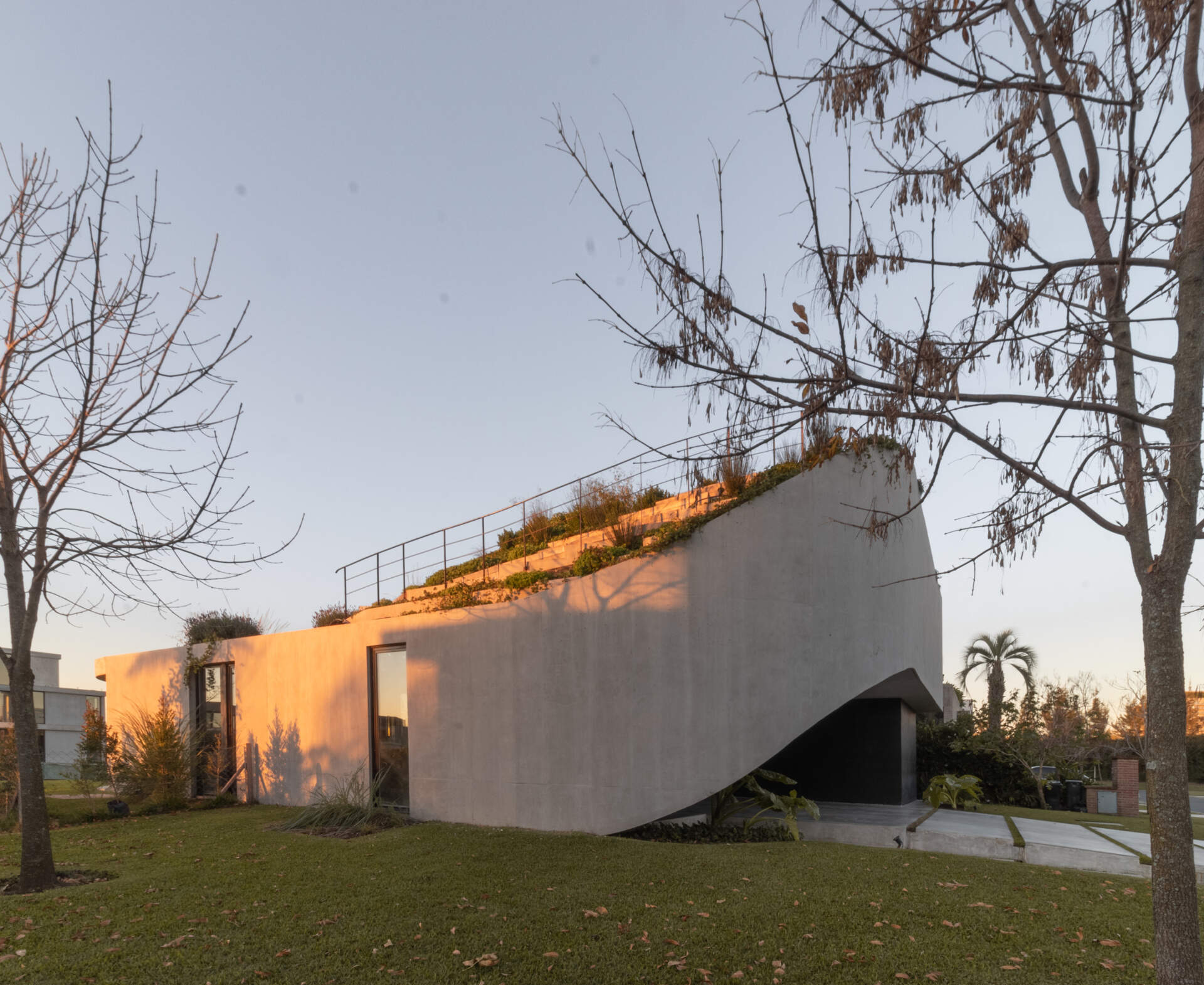 Explore the concrete architecture of GP House, featuring sculptural forms, expansive glazing, and a rooftop garden overlooking the lagoon.