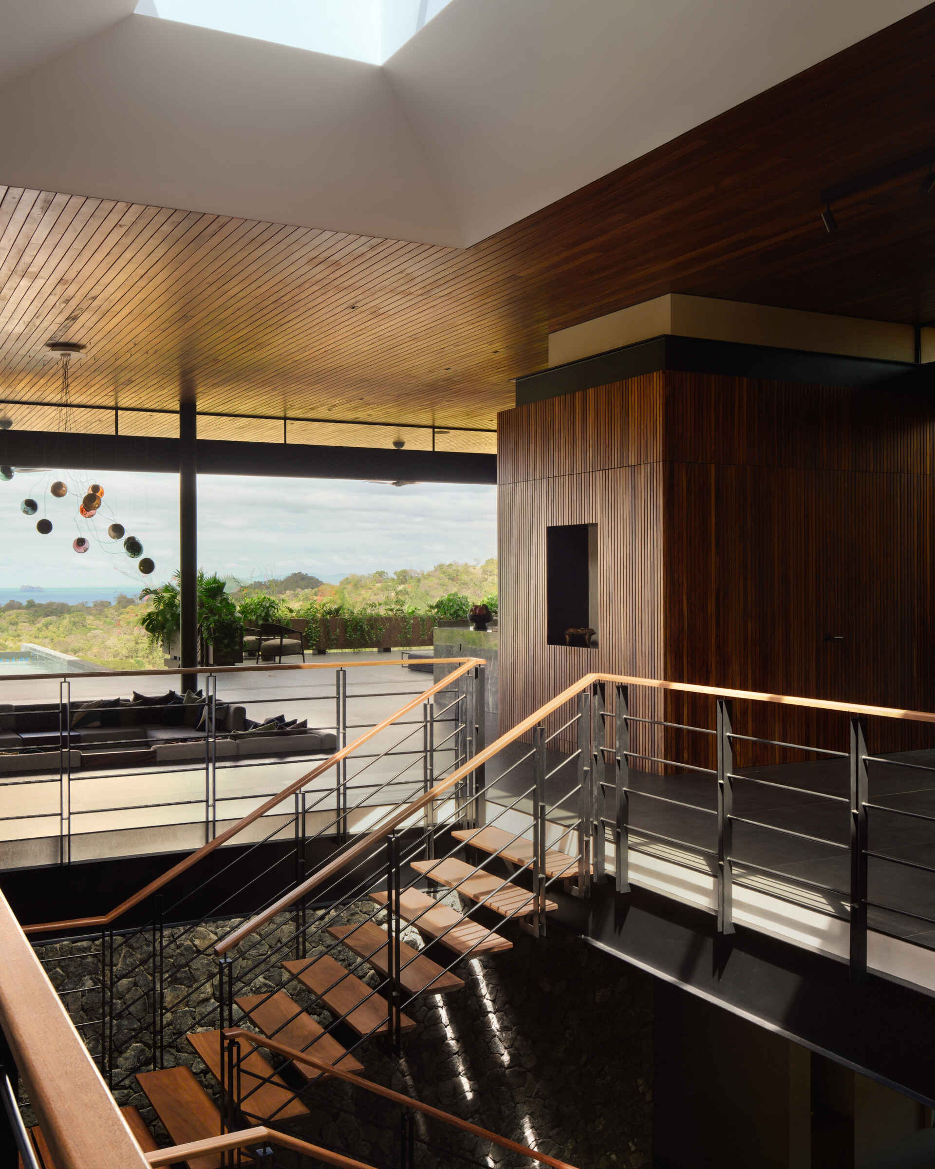 Floating timber treads, steel detailing, and lush planting transform this staircase into one of the home's standout features.