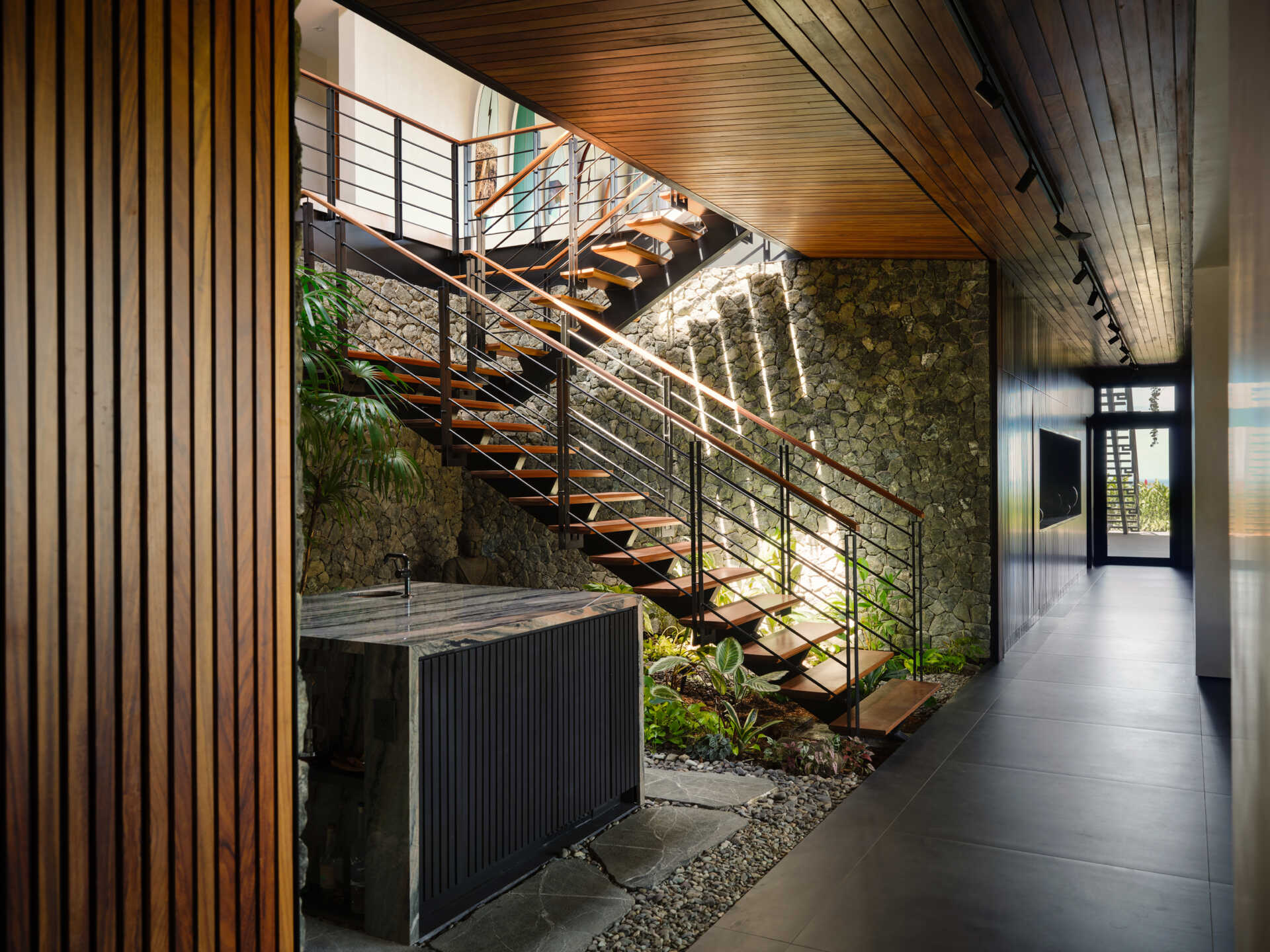 Floating timber treads, steel detailing, and lush planting transform this staircase into one of the home's standout features.