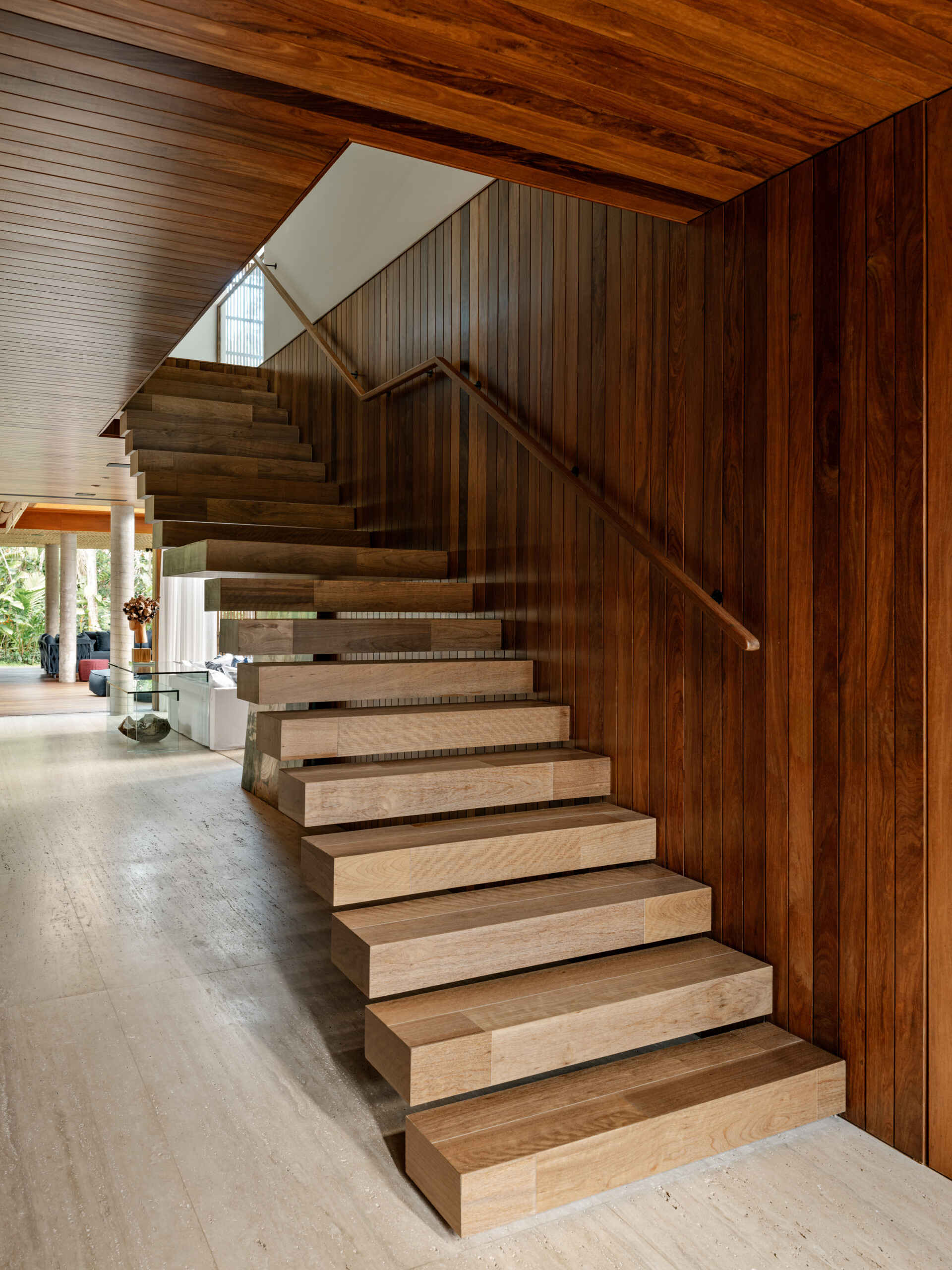 Wood stairs lead from the main living level to an open gallery hallway upstairs.