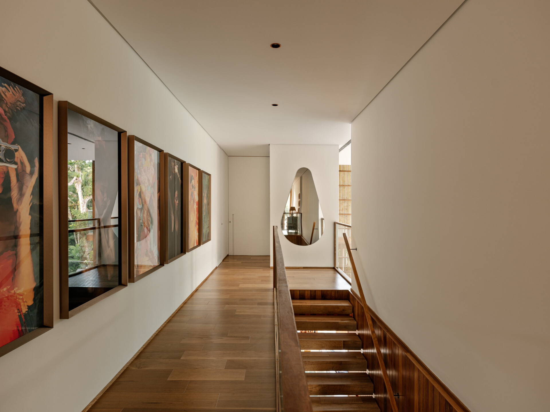 Wood stairs lead from the main living level to an open gallery hallway upstairs.