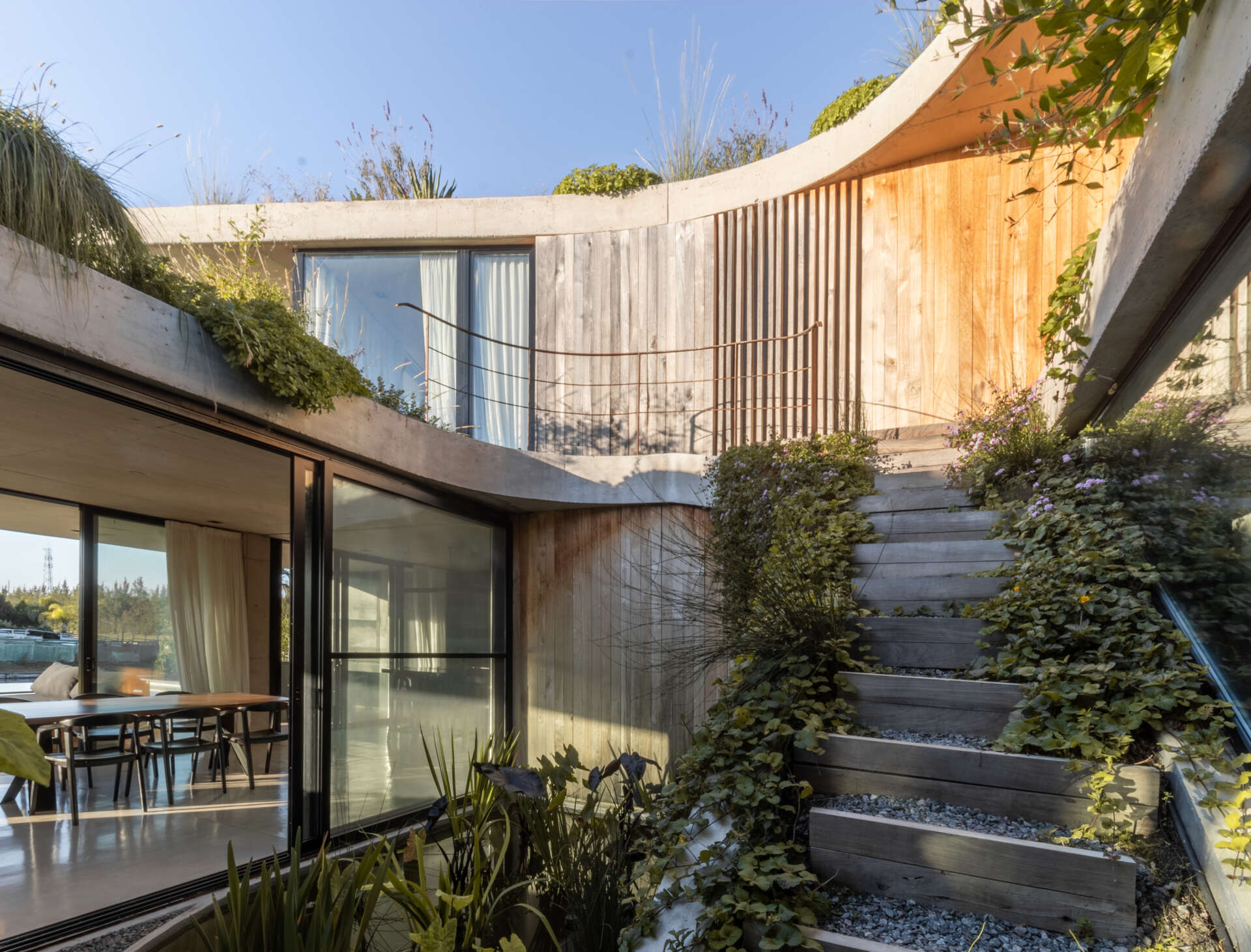 Discover how sliding doors and outdoor stairs connect the home's interiors with a lush rooftop garden overlooking the lagoon.