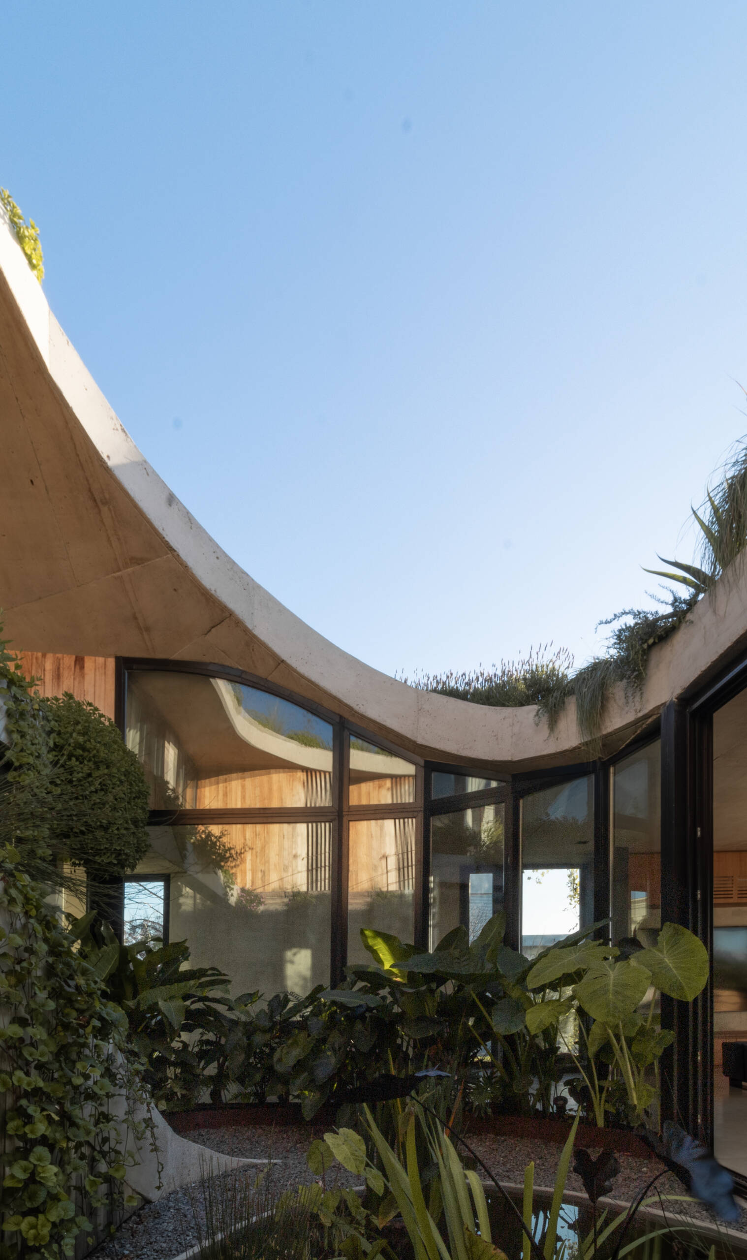 Discover how sliding doors and outdoor stairs connect the home's interiors with a lush rooftop garden overlooking the lagoon.